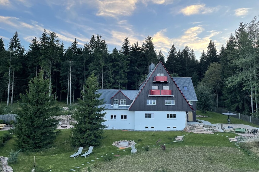 There is space and relaxation for the whole family on over 100m². Here, the four of you can simply be together and share unforgettable experiences.
A family pizza can be easily conjured up in the open and spacious kitchen. You can toast your friends to a delicious meal and spend a fun evening playing games at the large dining table right in front of the warm fireplace. The cozy living area and the view towards the Ore Mountains forest invite you to cozy evenings. The two bedrooms with double beds and a color-lit wellness shower round off the comfort.