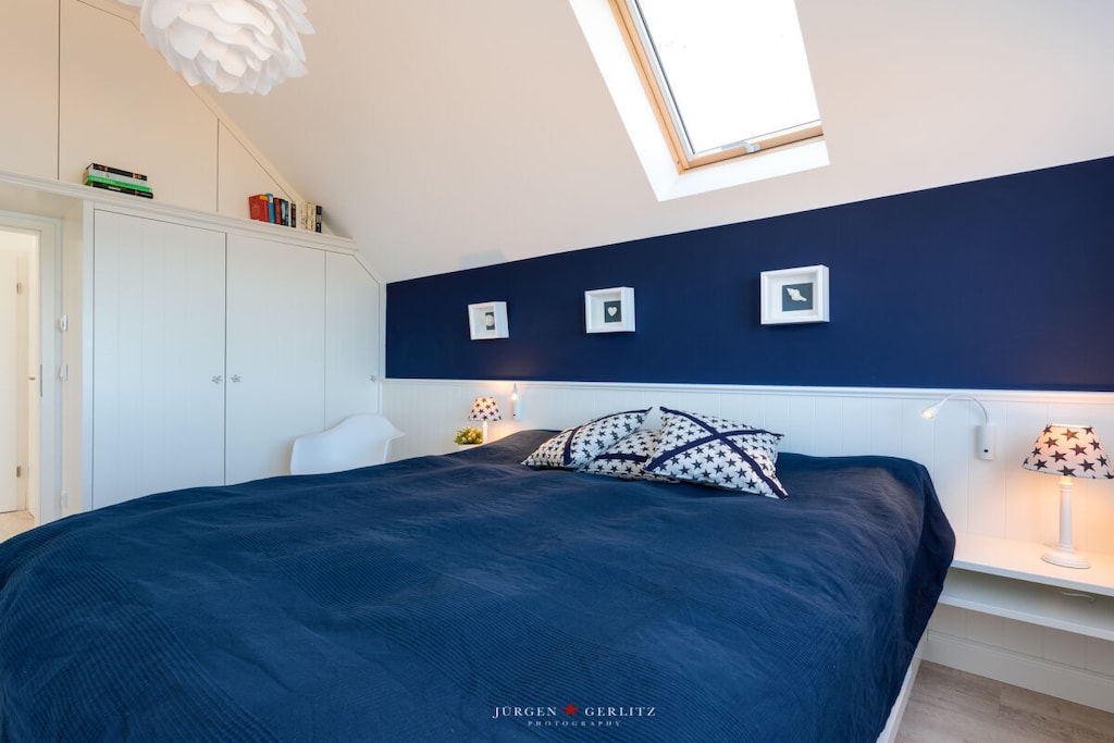 Welcome to this exclusive holiday apartment in the OstseeResort Olpenitz, just 20 meters from the water, right on the banks of the Schlei arm of the Baltic Sea. The apartment extends over two floors (1st and 2nd floor) and has been furnished with selected luxury furniture in Scandinavian style. As soon as you enter, you will be greeted by an inviting atmosphere. The panoramic windows in the dining area, the bedroom and the spacious bathroom offer you a breathtaking panoramic view of passing sailboats and the picturesque Schlei estuary. The great terrace offers the perfect place to relax and enjoy the view of the water. You can also experience the beauty of the surroundings from the panoramic windows in the living room. A fireplace not only gives the living area a cozy feel, but also creates a warm and inviting atmosphere. There is also a second balcony at your disposal, which offers a view of the greenery. The absolute highlight of this apartment awaits you on the top floor: a wellness bathroom that impresses with a whirlpool, rain shower and a private Finnish glass sauna with a view of the water. Here you can perfectly relax and leave everyday life behind you. The two bedrooms are also on the same floor and boast comfortable double beds, generous storage space and fantastic views of the water or the greenery. This stylish apartment can accommodate up to 4 people thanks to an extra bed.