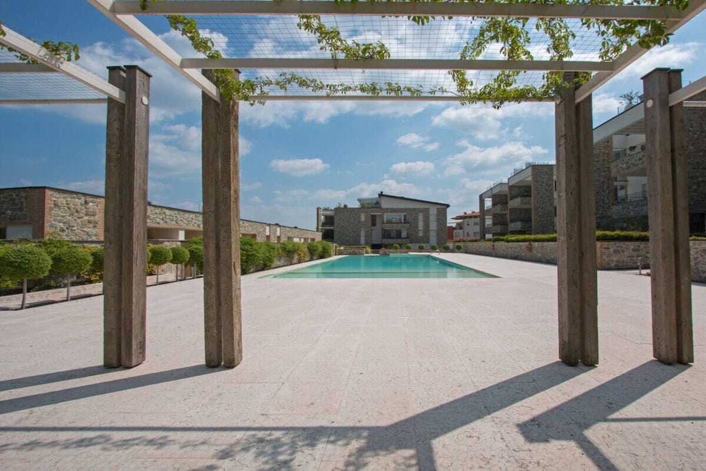 In Desenzano del Garda, in an exclusive residence with pool, a few steps from the beach and lake, 2 bedroom apartment for 5 people on the second floor with elevator, private terrace with lake and mountain views!
The apartment with free Wi-Fi internet connection welcomes guests with a large and bright living room, with a sofa bed for 1 person, flat screen TV, dining table with chairs, fully equipped kitchen with induction hob, fridge, freezer, microwave, coffee machine, toaster, kettle, citrus press.
The living room has a beautiful view of the private covered terrace from which you can enjoy a wonderful view of the lake and the mountains!
The apartment, equipped with air conditioning in all rooms, continues with the master bedroom, equipped with a comfortable double bed and small TV, the second bedroom, also equipped with a double bed and a small wardrobe, and the bathroom with shower, sink and toilet.
The furnishings of this apartment are completed by the washing machine, iron and ironing board.
Guests can conveniently park their car in the apartment's private garage.
The large pool (10 x 30 meters) is open from May 1st to September 30th.
With a small additional charge, possibility of providing a cot and a child seat.
Pets are not allowed.
Key collection/return at our office: Località Rovere 2, 25015, Desenzano del Garda, BS.
CODICE CIR: 017067-CIM-00385