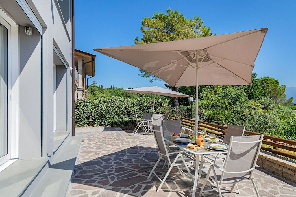 In a newly built two-family villa with shared swimming pool surrounded by greenery (olive and fruit trees) and a Jacuzzi (with 6 places) on the highest point of the property overlooking the lake, in the green hills of the Valtenesi in an oasis of peace, surrounded by nature trails for lovers of hiking and mountain biking, golf and horse riding, 1 bedroom apartment for a relaxing group or family holiday on Lake Garda.

The apartment, equipped with air conditioning in all rooms, welcomes guests with a comfortable double sofa bed, flat screen TV, dining table with chairs and an open kitchen equipped with induction hob, fridge, freezer, oven, microwave, citrus press, dishwasher, kettle, coffee machine and toaster.

From the living room you go out onto the beautiful private terrace equipped with a table and chairs for lunch and breakfast and a barbecue for preparing good meals! The apartment, with free Wi-Fi internet connection, continues with the master bedroom, furnished with a double bed and a wardrobe.

The bathroom with shower, sink, bidet, toilet and washing machine completes the apartment's facilities.

Guests can park their car in the uncovered parking lot of the property.

The shared pool is open from May 1st to September 30th. Swimming caps are compulsory at the pool.

Pets are not allowed.

*Children over 6 years of age are welcome at the property.

*The Castelletto 1 apartment is adjacent to the Castelletto 2 studio: the two apartments are separated by a door that always remains closed, so that the two apartments are completely independent.