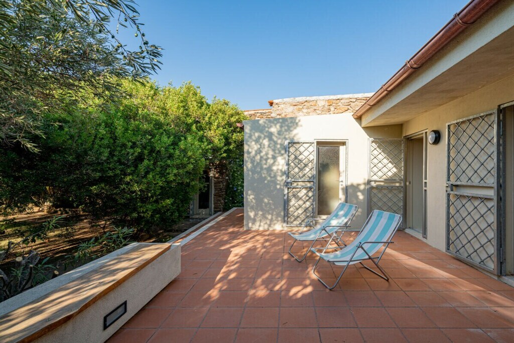 This villa welcomes its guests with a wooded garden and a large terrace that offers a relaxation area with armchairs, deck chairs and a coffee table, as well as a dining area with table and chairs. Here, a large French door leads to the open plan living area with a beautiful stone wall, decorated with design elements and furnished with an L-shaped sofa, coffee table, ottoman, TV, dining table and a fully equipped kitchen with oven, dishwasher and microwave. 

The sleeping area consists of four rooms. The master bedroom, also decorated with a stone wall, has a French bed, a closet with doors, a wardrobe, access to the terrace and a private bathroom with bathtub. The second and third rooms are both equipped with a double bed, a closet or clothes rack, a chest of drawers and access to the backyard. One of them also has a private bathroom with shower. The last room is equipped with a bunk bed, a desk and a closet and also has access to the backyard. A bathroom with a large sink and a washing machine completes the furnishings.

The villa has an additional outdoor area equipped with an outdoor shower, a long dining table and a fireplace.

Guests have access to amenities such as free Wi-Fi, air conditioning, heating and ironing facilities.