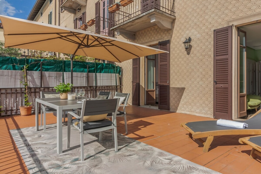 Located on the first floor of a historic building, the apartment offers an open plan living area with sofa, TV and dining table, as well as a fully equipped kitchen with microwave, dishwasher, kettle, juicer, toaster and coffee machine. The sleeping area consists of a bedroom with queen size bed, TV and a balcony overlooking the lake, and a bedroom with a queen size bed, TV and a private bathroom with shower. Another bathroom with shower completes the layout.
The highlight of the apartment is the large terrace, equipped with a dining table and sun loungers, where guests can enjoy the view of the lake and the surrounding mountains.
Guests have access to amenities such as washing machine, iron, free Wi-Fi, air conditioning and heating.
*Guests benefit from a garage near the property.