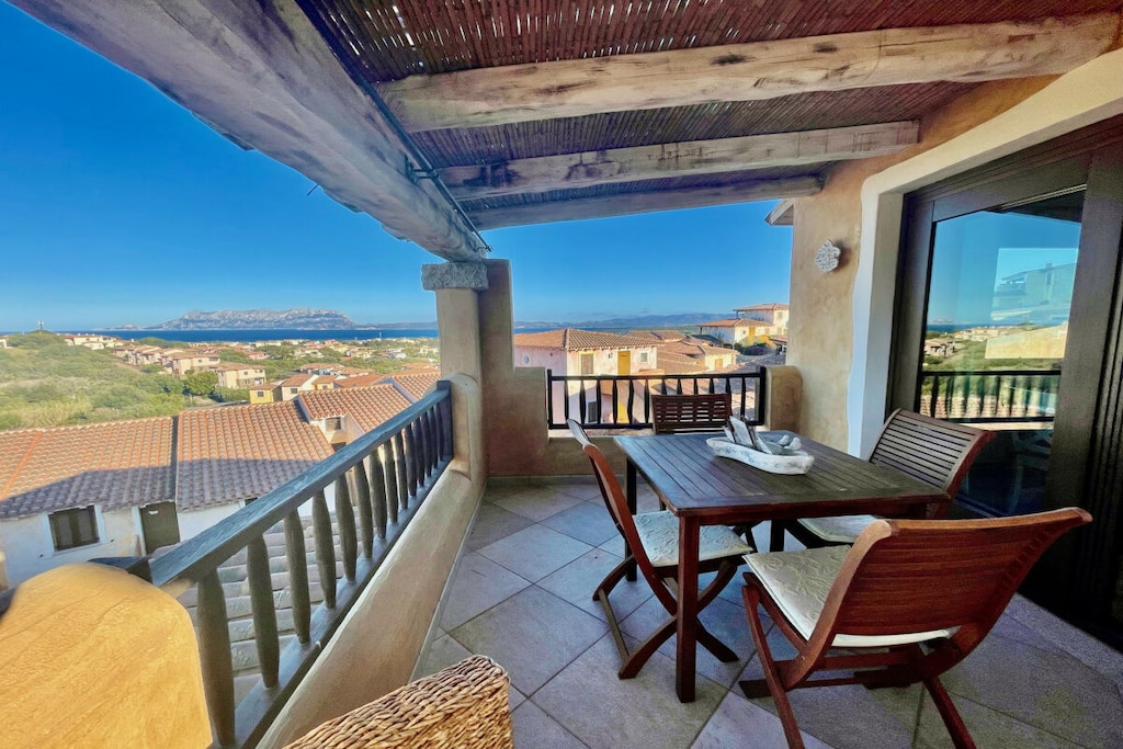 The apartment is located in a village in the north of Olbia, less than 5 minutes by car from Pellicano beach. It is spread over two floors and is characterized by a charming ceiling with exposed beams. On the ground floor there is the sleeping area, consisting of a bedroom with a queen size bed, a second bedroom with a bunk bed and a bathroom with shower. A staircase at the entrance leads to the living area on the first floor, a large open space furnished with a double sofa bed, a dining table and a fully equipped kitchen. From this floor there is also access to a covered terrace with a dining area and a beautiful sea view. A second bathroom with shower completes the setup. 

Guests have at their disposal amenities such as a washing machine, iron and air conditioning.

*Guests benefit from an outdoor parking space inside the property.