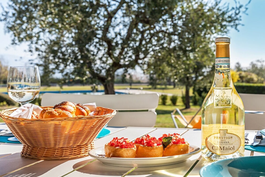 The apartment is located on the ground floor and is spread over two floors. It welcomes its guests in a bright living room with sofa, TV, dining table and open kitchen equipped with all amenities including oven, dishwasher, microwave, kettle and American coffee machine. From the living room you can see the large covered veranda equipped with a second dining table and deck chairs, ideal for enjoying sunny days outdoors. A double bedroom with wardrobe, a second bedroom with two single beds and a bathroom with shower complete the floor. A staircase leads to the lower floor where there is a spacious tavern equipped with a comfortable double sofa bed, a second sofa, a table with chairs and a TV. On the same floor there is the third bedroom with a bunk bed. A second bathroom with shower completes the furnishings.

At guests' disposal are amenities such as free Wi-Fi, a washing machine and a heat pump for colder days.

Guests benefit from an outdoor parking space within the property.

The communal swimming pool is open from May 1st to September 30th. A swimming cap may be required.