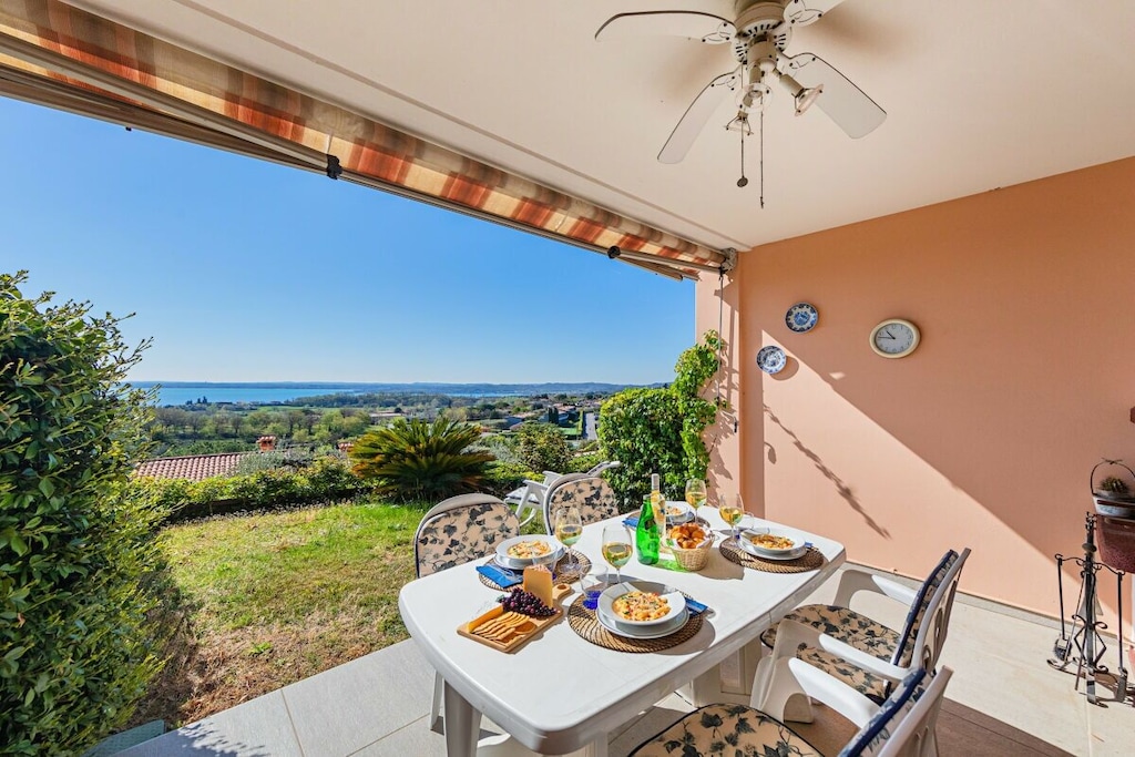 The apartment is located on the ground floor and opens onto the bright living room, furnished with a comfortable sofa bed, a dining table and an open kitchen equipped with all the necessary cooking utensils, including an oven, a dishwasher, a microwave and an American coffee machine. Through a French door you can access the private veranda with a wonderful view of the lake and the garden, equipped with a dining table and a barbecue, ideal for outdoor dining. A ceiling fan and an awning keep the room cool on the hottest days. The master bedroom, furnished with a double bed, has a spiral staircase that leads to the basement where there is a bedroom with two single beds and a private bathroom with shower.

A second bathroom with shower completes the apartment. 

Guests benefit from amenities such as independent heating for colder days, washing machine and free Wi-Fi.

A private garage with a parking space inside the house is available to guests.

The shared pool is available from May 1st to September 30th.