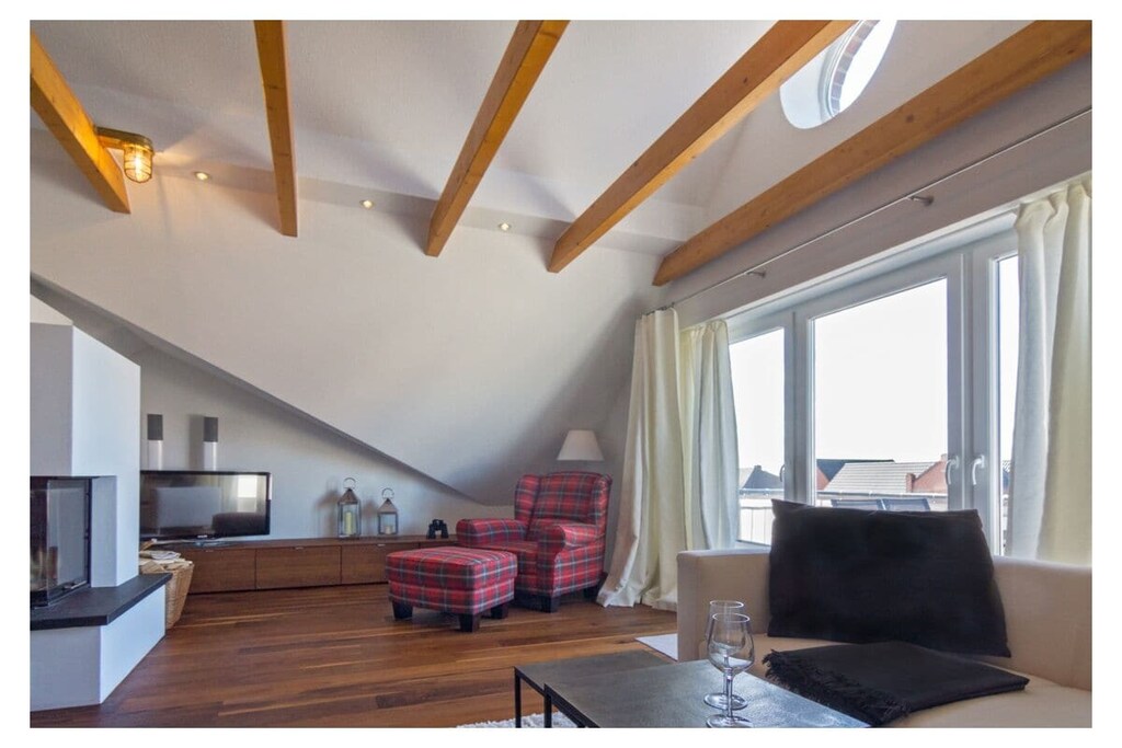 Holiday apartment Norddeich Loft
This elegant yet cozy penthouse apartment in the heart of Norddeich offers exclusive living flair - even during the holiday season. The apartment offers a loft-like, spacious living area that combines functionality and luxury in an appealing way. The living and dining areas are deliberately designed to be comfortable. The exclusive fitted kitchen from the "Bulthaupt" brand completes the representative open design of the loft. The parquet floor made of walnut wood, which also has a very luxurious character, is particularly exclusive. The wide window front ensures the perfect incidence of light. Thanks to the modern underfloor heating, comfort is guaranteed in every season. The apartment also has a fireplace in which a warming fire can be quickly lit in bad weather.
Two people can find space in the spacious master bedroom with the high double bed. Like the living area, this room is equipped with a modern flat-screen TV. A child can also find additional sleep in an additional extra bed. The loft also has a converted gable in which there is an unconventional mattress camp - ideal for older children who like to look out at the starry sky.
For a carefree start to your vacation, book our linen package. This consists of bed linen, towels, shower mats, tea towels and a service set (toilet paper, dishwasher tablets, garbage bags, dishwashing brush, cleaning cloths and other small helpers) for a carefree start to your vacation.