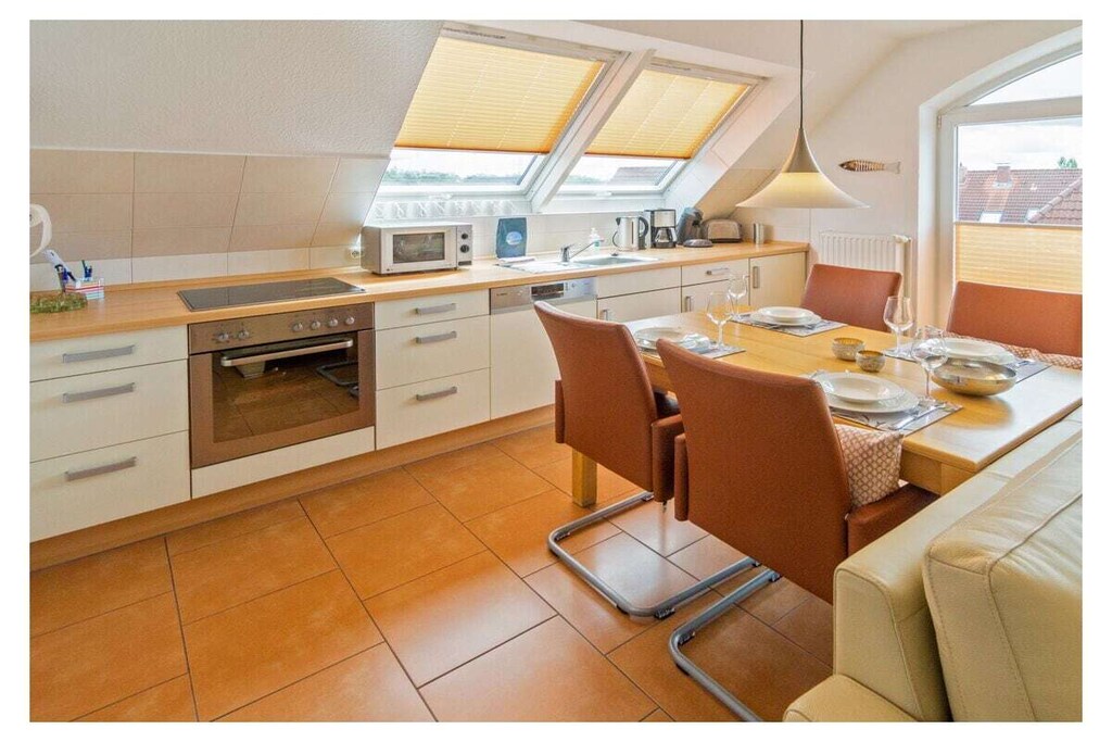 Sonnenplatz 30 - Kolkstr.30, Norddeich
Spend wonderful holidays in Norddeich. In this beautiful holiday apartment you benefit from the central location. Just a few steps and the beautiful city center with its numerous small shops, gastronomic offers and the various leisure activities are reached. Since the holiday apartment is located in an apartment building in a very quiet side street, you can still look forward to quiet and relaxing days, far from any tourist hustle and bustle.
The holiday apartment
This very bright and friendly holiday apartment offers space for four people. Whether with friends or family, you will feel completely at home here. The heart of the apartment is the tastefully furnished living and dining area with integrated fitted kitchen. The modern and at the same time cozy living environment is a wonderful place to relax. The seating area is equipped with a comfortable couch and a modern TV, so you can expect cozy holiday evenings here. Adjacent to the living room is the access to your balcony. Thanks to the southwest orientation, you can enjoy the sun here in the afternoon and into the evening. The sunset can be viewed from the seating area. This is a fitting end to a wonderful day.
The modern and functionally equipped kitchen offers plenty of space for cooking together. Here you will find everything you need to prepare a good meal: stove with oven, coffee machine, refrigerator, microwave, dishwasher in the kitchenette, toaster, egg cooker, dishes, glasses, mugs, etc. You can eat together at the beautiful dining table with four chairs.
The apartment has two bedrooms. The first is furnished with a 180 x 200 cm double bed. The wardrobe offers plenty of space for your clothes. The second bedroom also has a double bed, this one with