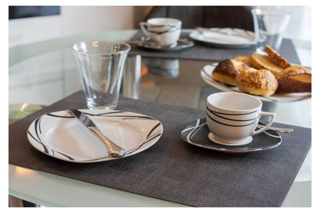 Holiday apartment Leuchtfeuer 1 ground floor
A stay in this beautiful and bright holiday apartment promises unadulterated holiday pleasure. The apartment is in a central location in Norddeich. The regional leisure activities, restaurants and numerous shops can be reached in a few minutes on foot. In the middle of the action, you can also enjoy absolute peace and quiet, because the apartment building is located in a quiet side street with no traffic. This means you can enjoy all the advantages of your Norddeich holiday - relaxation and leisure activities - to the fullest.
The holiday apartment
The very bright and friendly holiday apartment has space for two people. A lot of emphasis was placed on creating a cozy ambience when furnishing it. At the same time, the black and white color scheme and the sparing, but carefully selected decoration appear very modern. The entire apartment has been laid out with modern and practical tiles. The heart of your holiday home is the living and dining area with integrated fitted kitchen. This is where you can come together, whether to relax in the comfortable sofa corner in front of the TV, to have a quiet chat, to cook together in the modern kitchen or to eat together at the dining table. The TV area is equipped with a DVD and Blu-ray player, so nothing stands in the way of your cozy evenings in front of the TV. There is also access to the garden here. With its southeast orientation, it offers you the opportunity to enjoy the sunrise on nice days and thus start the day properly. The integrated seating area ensures comfort. The beach chair provides a real North Sea flair. A charcoal grill is also available.
The fitted kitchen is equipped with everything you need for cooking together. You will find a stove with oven, a modern coffee pad machine, a refrigerator, a microwave, a dishwasher and a coffee machine.