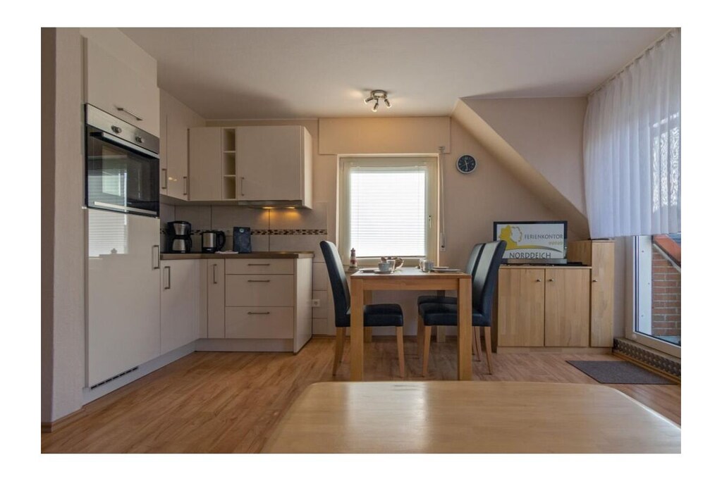 Holiday apartment Lima, Am Koper Sand 16, Norddeich
Norddeich welcomes you to a perfect North Sea holiday where you will want for nothing. Located directly on the wonderful, eight-hectare sandy beach, the tranquil district of Norden offers a diverse infrastructure. Stroll through the wide streets of the popular coastal resort, try out the gastronomic offerings and browse through the pretty little shops. In addition, there is a varied leisure program in and around Norddeich that leaves nothing to be desired and guarantees fun and relaxation for the whole family.
The holiday apartment
Our holiday apartment Lima is on the first floor of a detached house with a total of four residential units. The property is located in a quiet side street, so nothing will disturb your well-deserved rest. Nevertheless, it is only a few steps to the lively center of Norddeich with its diverse offerings. Just as quickly, in just a few minutes, you can be on the wonderful kilometer-long Norddeich beach.
Your holiday apartment is cozy and comfortable and has space for three people. The heart of the apartment beats in the lovingly designed and light-flooded living and dining room with the small kitchenette and the adjoining dining area. Here you can relax in the cozy 2-seater sofa corner, read a book or enjoy evenings watching TV together.
The kitchen is functionally furnished with everything you need for cooking together. The equipment includes a stove with four hotplates, a refrigerator, a coffee machine, a toaster, a mixer and of course a set of dishes, glasses and mugs. Take your meals at the dining table with the three matching chairs, which is placed directly next to the kitchen unit.
If it is too bright for you in the light-flooded apartment, the windows can be darkened for the most part with blinds or pleated blinds.
From the bright,