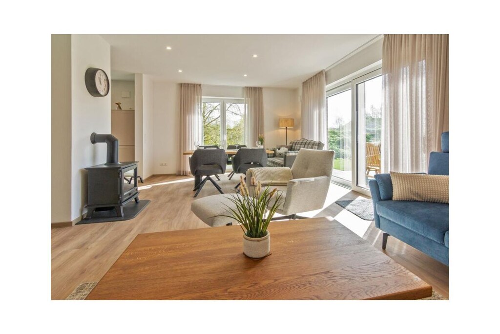 Holiday home LÃ¼ttje Steern
As a traditional health resort on the North Sea coast, Hage is known for its healthy sea air and mild, stimulating climate. Surrounded by green meadows, Hage offers an ideal environment for those seeking relaxation and nature lovers. The quiet atmosphere and the variety of leisure activities make it a popular destination for a relaxing holiday in the midst of North German nature. 
Immerse yourself in the relaxed atmosphere of Hage and enjoy the beauty of the North German coast when you move into our exclusive holiday apartment "LÃ¼ttje Steern".
"LÃ¼ttje Steern" is a real gem among the holiday apartments in Hage. Our charming holiday apartment is located in a newly built semi-detached house in the middle of a quiet residential area. It extends over two floors, is designed to accommodate four adults and offers the ideal retreat for a relaxing holiday on the North Sea coast.
Enjoy that very special something as soon as you enter this holiday apartment. The open design of the living area is inviting and spacious, and welcomes you with light.
The harmonious combination of kitchen, dining area and living room creates a warm atmosphere in which you immediately feel at home. The comfortable sofa set with matching armchair and the large TV monitor invite you to spend sociable evenings with friends. A modern electric fireplace, equipped with the latest effect fire technology and crackling effect, completes the cozy ambience.
The adjoining dining area is also located in this living area. The large table with its four chairs and a cozy Friesian sofa offers enough space for four people. Be it for breakfast together, a sociable game night or for a home-cooked dinner in the evening.
The modern kitchen is fully at your disposal for this. It is a real highlight and offers everything your heart desires.