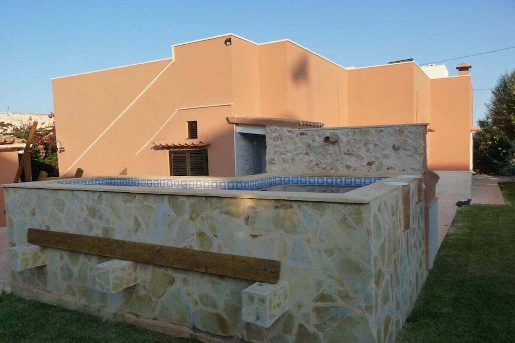 Ground floor: (hallway(Mirror, Wardrobe Coatrack), Kitchen(Egg Cooker, Fan, Tea Towels, Kitchenette, stove, hob, electric kettle, toaster, coffee machine, oven, microwave, dishwasher, fridge, freezer, insect screens), Living/diningroom(Armchair, Fan, Mirror, Sofa, library, TV, dining table, stove, stereo unit, insect screens), bedroom(Bed Linen, Wardrobe, double bed, TV, air conditioning, insect screens), bedroom(Bed Linen, Wardrobe, single bed, single bed, TV, air conditioning, insect screens), bathroom(Make Up Mirror, Mirror, toilet, shower, washbasin, bidet, heating, hairdryer, insect screens, Towels incl.), guest toilet(Mirror, toilet, washbasin, washing machine, insect screens), storage(Vacuum Cleaner, ironing board, iron, drying cabinet))\n\nHot Water, Vacuum Cleaner, veranda(outdoor shower, Lawn, grill, hot tub, garden furniture, sun loungers), veranda(garden furniture, sun loungers), Internet access, First Aid, washing machine, parking, deckchairs, bicycles available, ironing board, iron, drying cabinet, Laundry Package for a fee