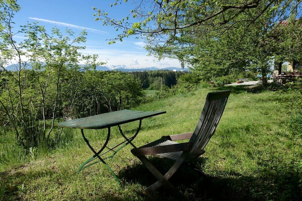 A cozy, stylish country house, with a fantastic mountain view of the nearby Alps and a natural garden - a wonderful place to slow down. Particularly suitable for children!
The former hunting lodge is the grandparents' heirloom, which we have lovingly renovated. It is located on the edge of the village on a hill near Penzberg, about 45 minutes by car south of Munich.
The sunny, wind-protected terrace can even be enjoyed in winter.
All rooms are on the ground floor: 3 bedrooms; 1 cozy living room; new, fully equipped kitchen; bathroom with tub; toilet. (The upper floor is not occupied.)
Sleeping space for about 7 people: Double bed 180x200 in the 'bell room'. Double bed 160x200 in the front (through) room. Bunk bed 100x200 in the back room. Sofa bed in the living room.
In addition, the renovated children's hut in the garden offers a 2x2m bedroom and a playroom with a table.
The large, natural and fenced garden with old trees invites you to relax and play. A swimming pond is 3 km away.