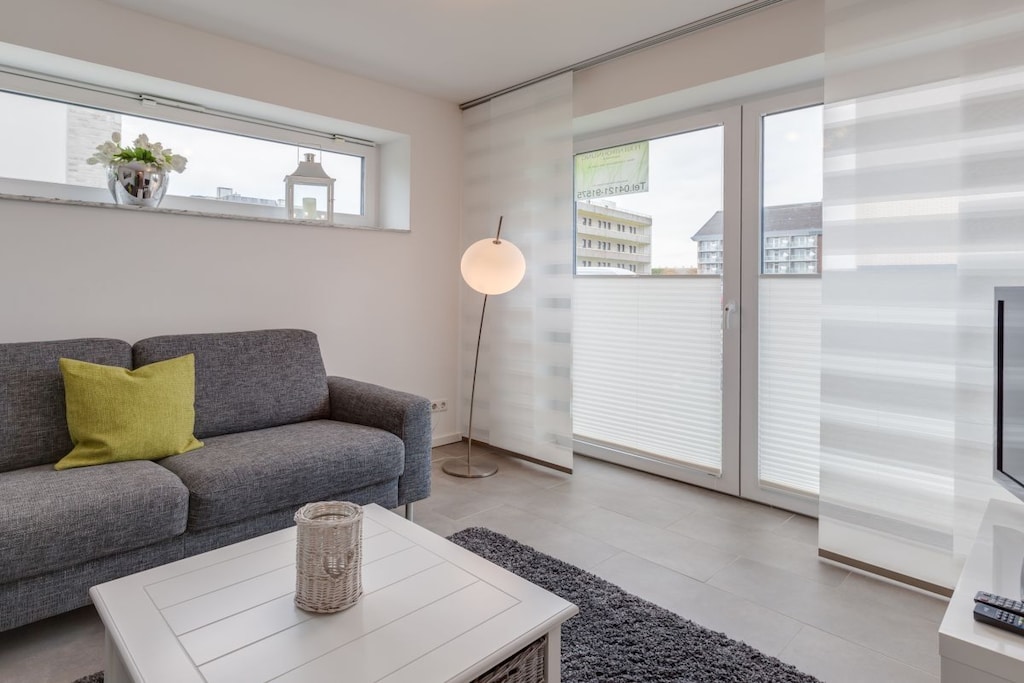 The 84 sqm ground floor holiday apartment for 2-4 people consists of a living room with an open-plan kitchen and integrated dining bar, as well as access to the terrace and garden, two bedrooms, a shower room, a guest toilet, and a hallway.
The living and dining room feature a dining area and a seating area.
The bathroom has a walk-in shower.
The partially covered terrace is equipped with a beach chair and garden furniture.
The holiday apartment includes a free parking space in the underground garage (parking meter, not suitable for every car, max. height 1.50 m, max. weight 2 tons, the operating instructions must be read before use... Instructions are available on site). If your vehicle is not suitable for the parking meter, we can also provide you with an outdoor parking space. Please inquire.