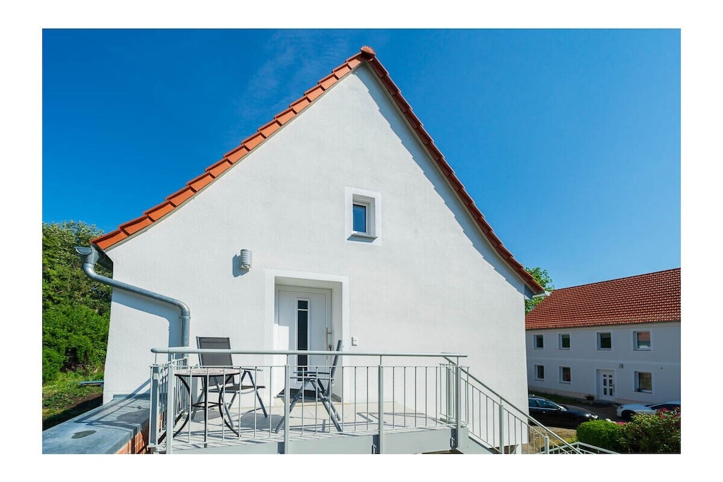 Lovingly furnished 100-square-meter holiday home with an open gallery level over two floors, with a balcony-like outdoor platform, surrounded by green gardens, with recreational rooms, garden, 100-cubic-meter fish pond in the garden, view of the church tower, church garden, park and the fields and mountains of the Leipzig lowland bay. The holiday home was created from the former agricultural commercial rooms of the building built in 1840 and will not be completed until 2022. The former three-sided farm in the historic center of a Saxon community with 3,500 years of history is a socio-cultural center that combines rural gentle tourism with local culture. This means that all families interested in multi-day relaxation stays feel at home here.