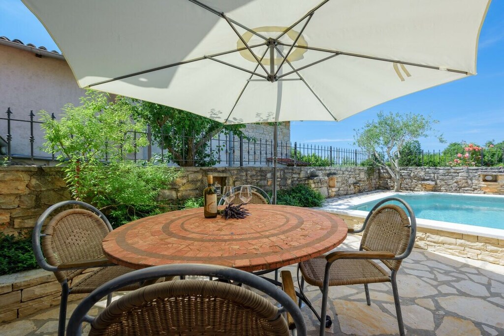 Casa Biguli is an authentic Istrian stone house dating back to 1896. The house has been renovated and combines old and new elements.
The house offers every comfort and exudes traditional charm. The main feature of the house is a large covered terrace with a barbecue. It's like an open-plan living room. The private pool is located at the rear of the house. There's an open-plan garage.
The house consists of a living and dining area, a kitchen, and a small toilet with a washing machine on the ground floor. Two bedrooms, one large with a double bed and the other smaller with two single beds, are also located on the ground floor.
There's also a bathroom with a bathtub and a large covered terrace overlooking the pool and nature.