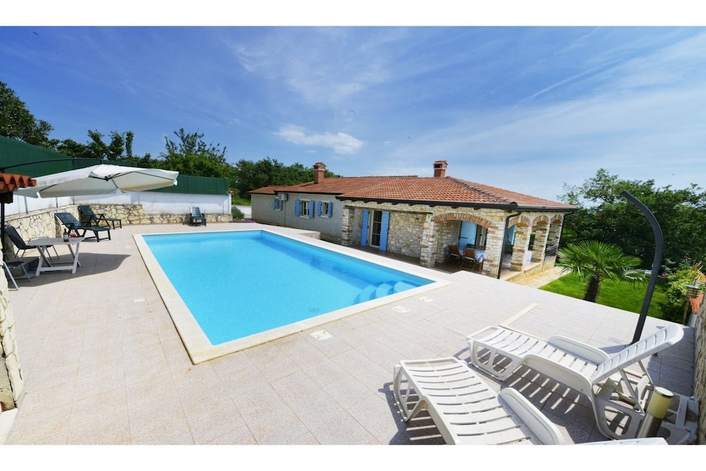 Villa Dany is located in Kastelir, a village about 15 km from Poreč. The villa features a pool, a fully fenced garden, a private garden, and a parking space within the garden.
It consists of three bedrooms, a toilet and a bathroom with a bathtub, a fully equipped kitchen, and a spectacular living room overlooking the pool and the sea. The villa is perfect for children. The entire villa is on the ground floor only. There are two bedrooms with double beds, and the third bedroom has a smaller double bed (140 x 200 cm) and a bunk bed. The living area is combined with a dining area, overlooking the covered terrace on one side and the pool on the other.