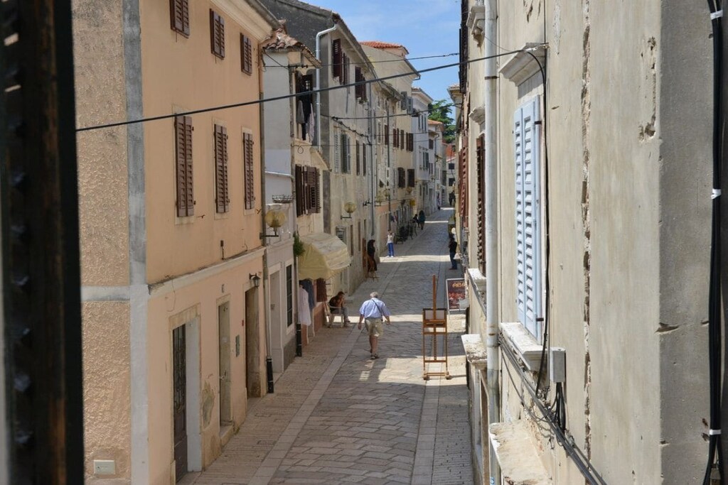 The "Andrea Old Town" apartment is centrally located in Porec's Old Town, yet still in a quiet location.

It is close to the famous Euphrasian Basilica, just a few meters away.

The apartment consists of a living room, a kitchen, and a bathroom with a shower on the lower level, as well as two bedrooms (one with a double bed, the other with two single beds) on the upper level.

There is also a private garden with garden furniture and a barbecue.