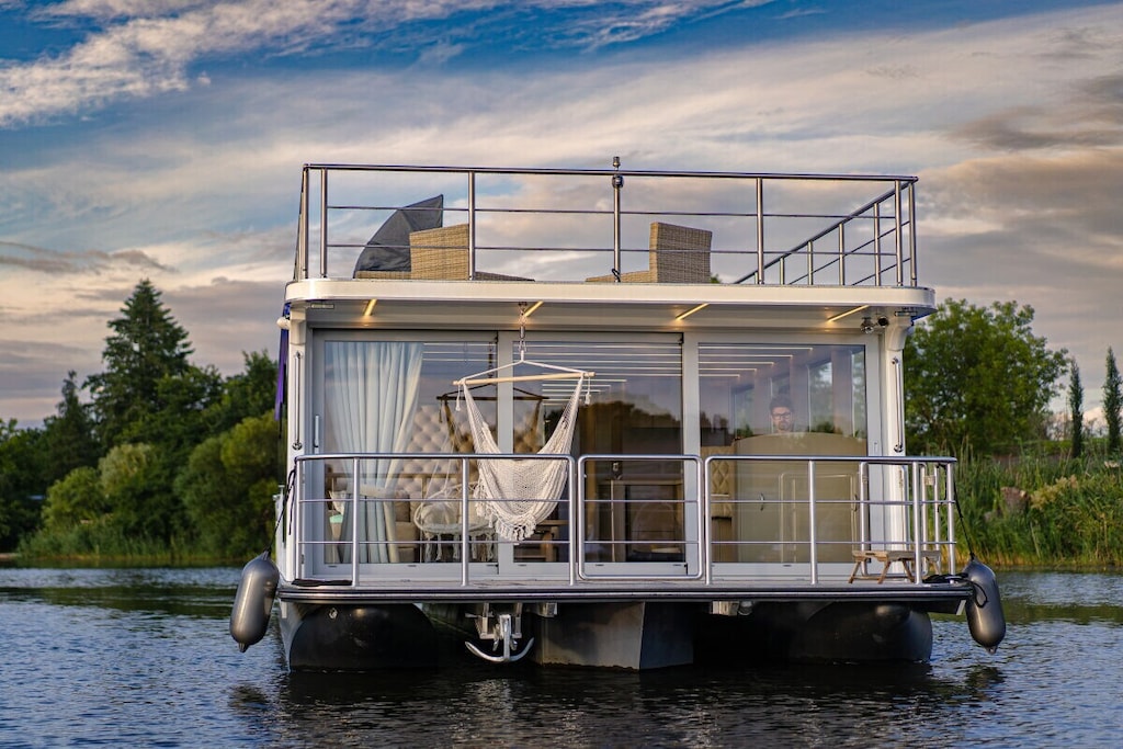 The high-end harbor suite was designed for discerning guests seeking relaxation, privacy, and that certain something extra. Discover how a vacation becomes THE experience! Your floating holiday home – comfort and luxury at the highest level. The modern, permanently moored houseboat offers ample space and privacy for up to four people. The generous layout with two separate bedrooms guarantees restful nights and individual retreats. Plenty of natural light, stylish colors, and thoughtful furnishings create a welcoming atmosphere where you'll feel at home from the moment you arrive. A fully equipped kitchen and an outdoor kitchen with a grill encourage you to be self-sufficient.