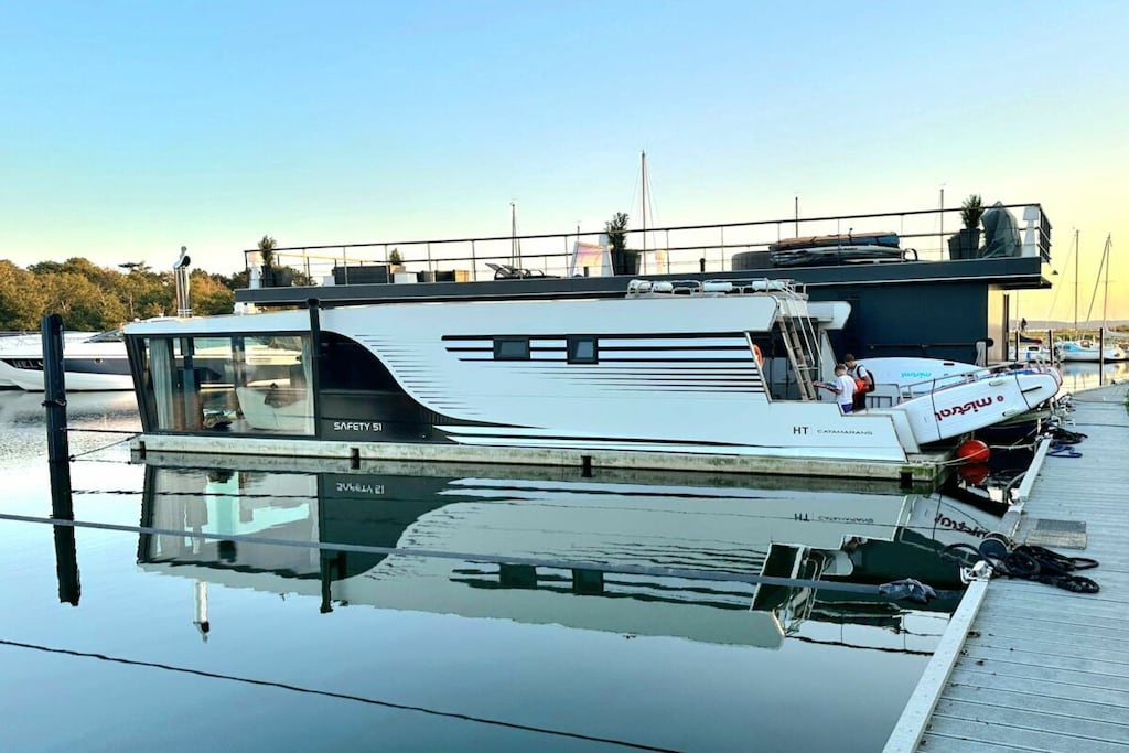 You can't get any closer to the water for a holiday. The idyllic and currently growing little harbor on the Jasmund Bodden – Martinshafen – is home to a unique, permanently moored houseboat with a suite-like atmosphere. From the bed, you can gaze through the large panoramic window across a whirlpool tub directly into the harbor, enjoying unparalleled views of nature and birdlife. A massage chair and a fireplace provide a special wellness experience. A small dry sauna and two bathrooms with large showers complete the luxurious amenities. A second, separate cabin offers an additional retreat. A refrigerator, sink, coffee maker, and toaster allow for self-catering. Breakfast can be ordered at the harbor bistro. Just around the corner, the beach invites you to enjoy water sports or simply relax and watch the waves.