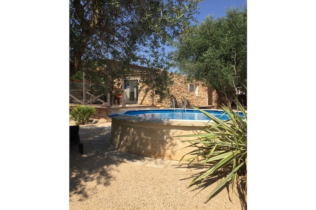 Our luxurious, lovingly self-sufficient, and sustainably restored trullo cottage is ready for any season. It features air conditioning for cooling and heating. The cottage includes a bedroom, a bathroom with shower, toilet, and washing machine. The living area boasts a spacious kitchenette with dishwasher and dining area, as well as a comfortable corner with a sofa bed for two people, satellite TV, and Wi-Fi. An additional bed (for a child) or extra bed can be provided; the cottage is equipped with all the amenities for daily comfort.

Relax and sunbathe in the garden and olive grove; the pool (open from June to October) offers a refreshing dip. An outdoor shower with hot and cold water, a terrace, and a barbecue area are also available.

Sustainable accommodation.