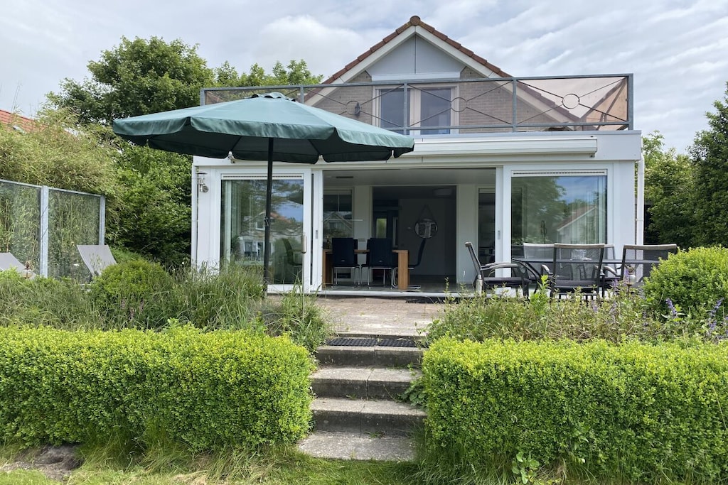 Ground floor: (Kitchen(Armchair, Bed Linen, Mirror, Sofa, Sun Umbrella, Tea Towels, Kitchenette, toilet, sauna, Barbecue center, single bed, double bed, dining table, stove, electric kettle, toaster, coffee machine, oven, grill, microwave, dishwasher, fridge, freezer, bath tub, shower, washbasin, washing machine, garden furniture, sun loungers, children\'s bed, high chair, hairdryer), guest toilet(Mirror, toilet, washbasin), relaxation area(sauna), conservatory(Armchair, dining table), storage(Vacuum Cleaner, tumble dryer, washing machine, drying cabinet))\n\nOn the 1st floor: (bedroom(Armchair, Bed Linen, Wardrobe, single bed, single bed, single sofa bed, double bed, TV, cot), bedroom(Armchair, Bed Linen, Wardrobe, single bed, single bed, single sofa bed, double bed, TV, cot), bedroom(Armchair, Bed Linen, Wardrobe, single bed, single bed, single sofa bed, double bed, TV, cot), bathroom(Make Up Mirror, Mirror, toilet, bath tub, shower, washbasin, hairdryer))\n\nHot Water, Pier, Vacuum Cleaner, Internet access, Internet access, First Aid, tumble dryer, washing machine, heating, terrace(Sun Umbrella, grill, garden furniture, sun loungers), parking, deckchairs(Sun Umbrella, garden furniture), bicycles available, stair gate, drying cabinet