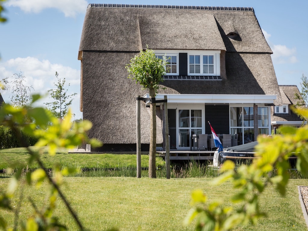 Rietgedekte villa met lounge set, aan het water