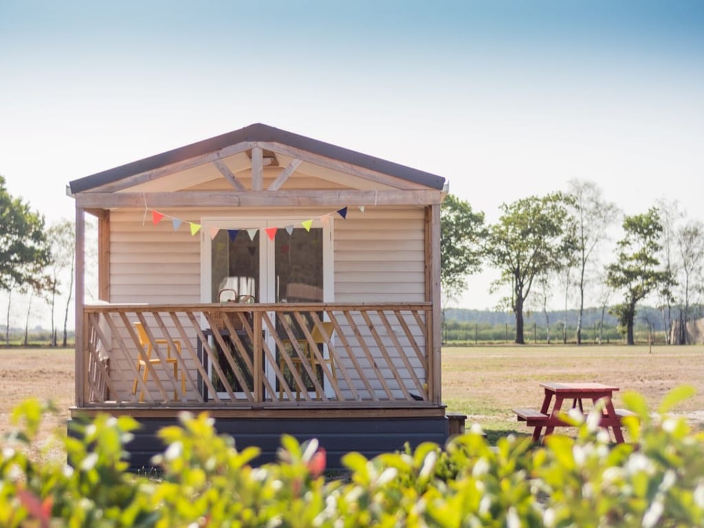 Vakantiehuisje met zicht op zwemvijver, speeltuin