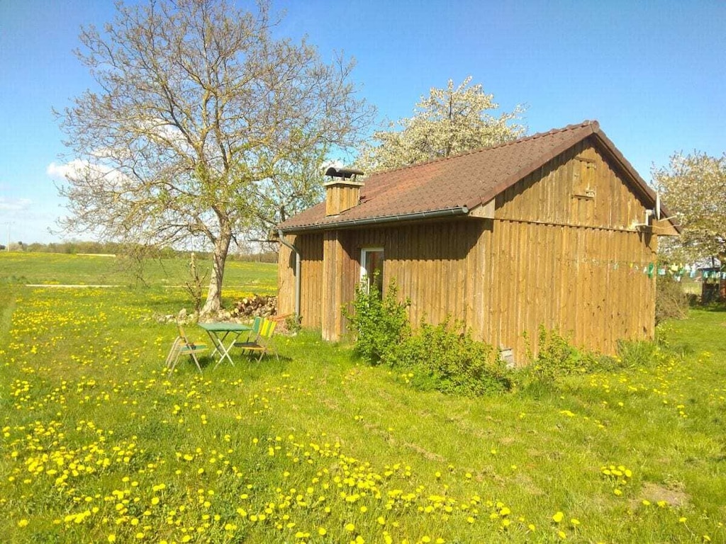 Prachtige houten blokhut in een groene weide.