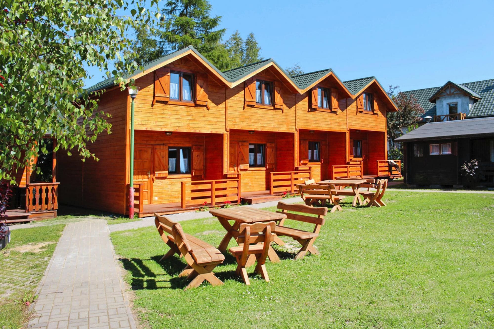 Vakantiehuis met twee verdiepingen en een terras, vlakbij het strand.