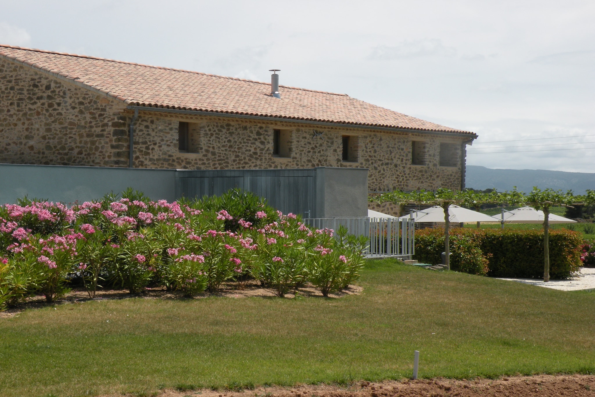 This holiday home is located on an estate amid 160 hectares of vineyard, overlooking the Montagne d'Alaric and the peaks of the Pyrenees. It is very suitable for family holidays. The restored farmhouse from the eighteenth century consists of 3 living areas named after grape varieties from the region: Muscat, Grenache and Syrah. The gîte Syrah is occupied by the owner who is present on the property for maintenance and welcoming guests.
The accommodation is part of the Parc Régional du Languedoc nature reserve, 9 km from the Canal du Midi and 2.8 km from the village of Rieux. The nearest airport and train station are 26 and 35 km from the property, respectively.
On the south-west side of the house is a vast terrace divided by a hedge between the 3 accommodations; thus, each accommodation has its own terrace with furniture and barbecue. The swimming pool with jet stream and a separate sun terrace with pool house (shower, toilet and storage room) is for shared use. The gîte Grenache has a spacious area, a sitting area with smart TV, music system and WiFi, its own Bulthaup kitchen and a bathroom with walk-in shower.
Gite Grenache is equipped with AIRCO ( heating and cooling ) i.f.v. consumption with separate meter reading : to be paid on the spot: 1€/kwh.