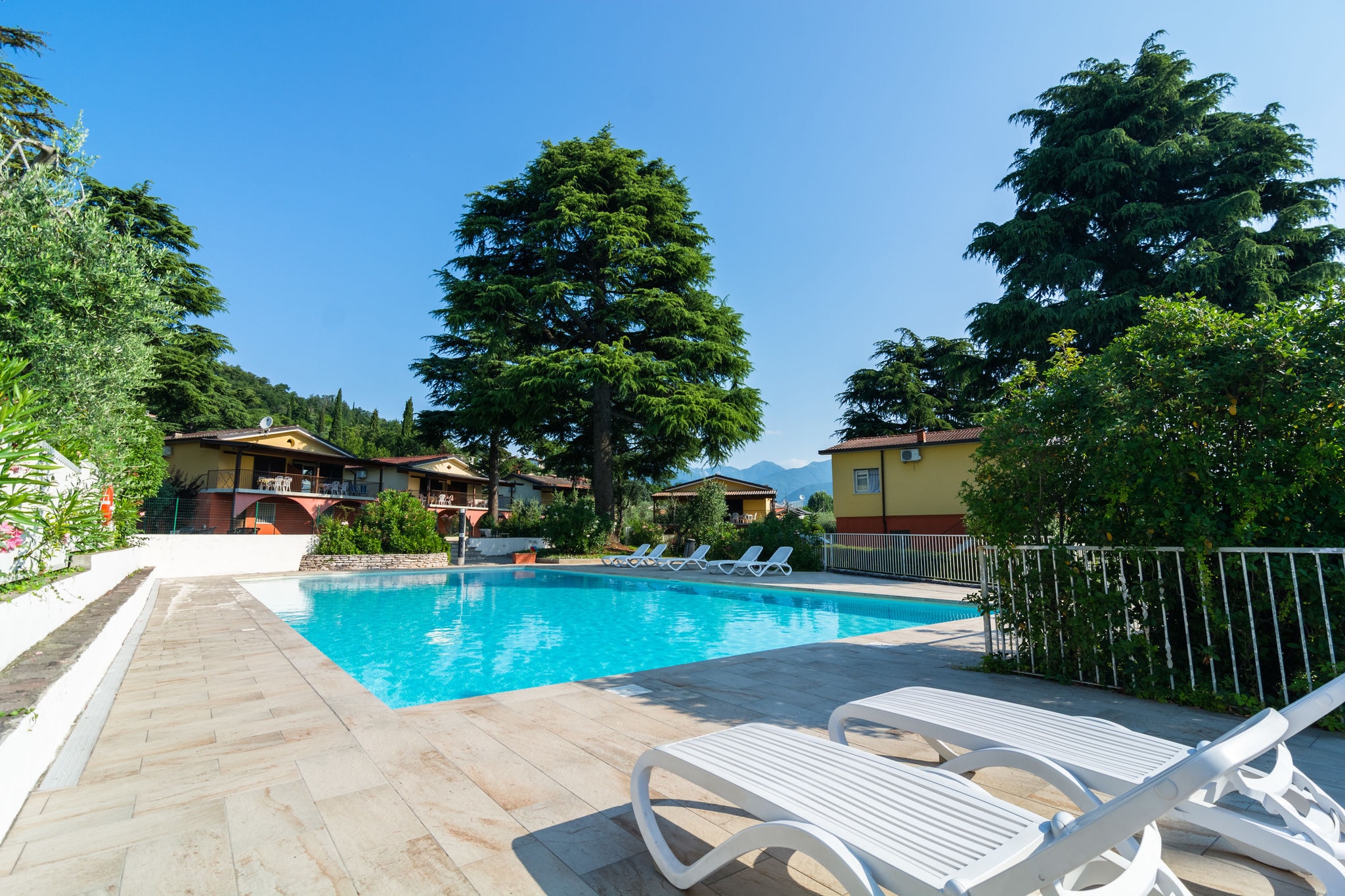 Apartment on Lake Garda with pebble beach, pier for boat, three swimming pools