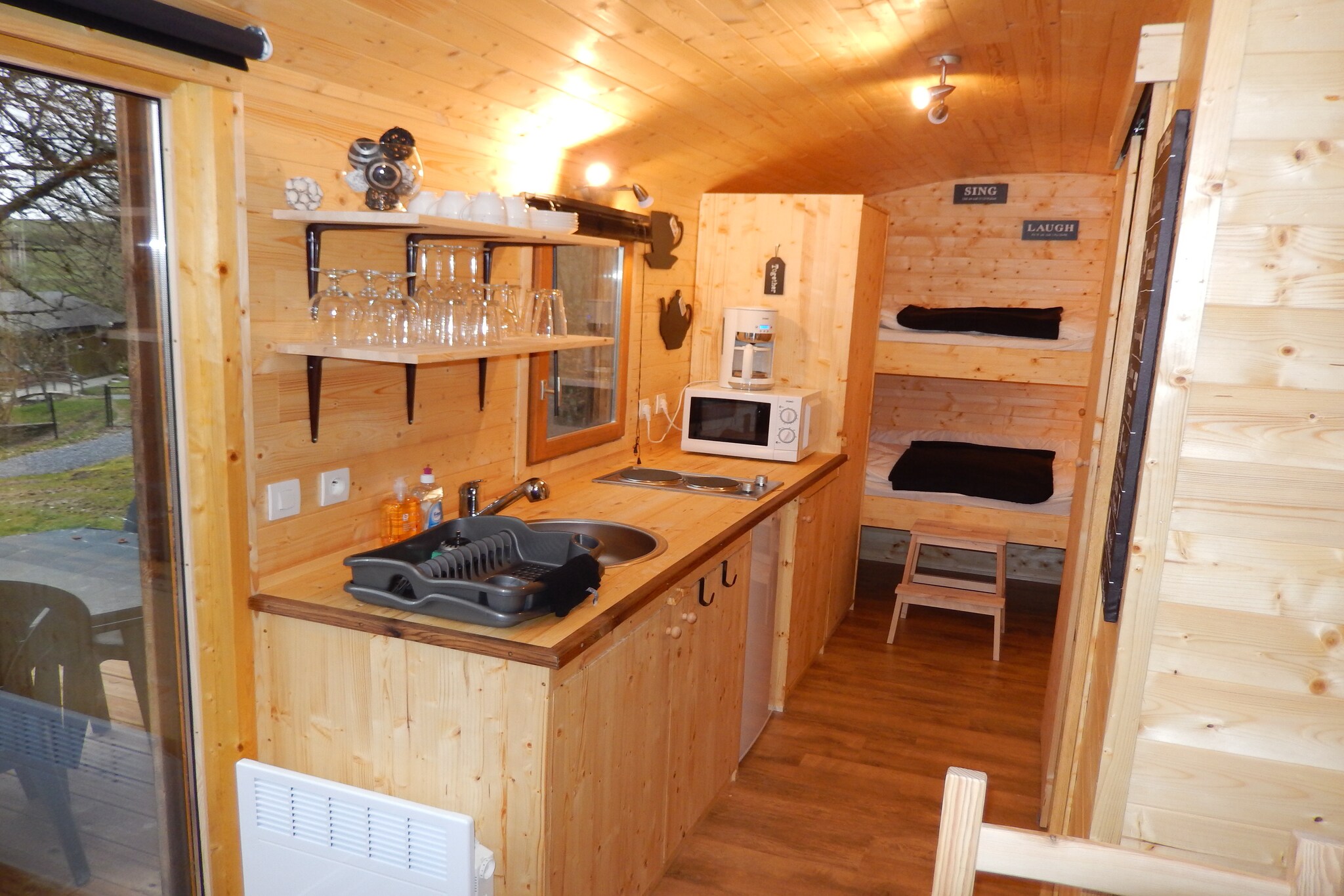Covered waggon: (open kitchen(microwave), Living/bed room(double bed, bunk bed, TV, DVD player), bathroom(shower, washbasin), toilet)\n\nmezzanine, heating(electric), garden(shared with the the owner and other guests), parking