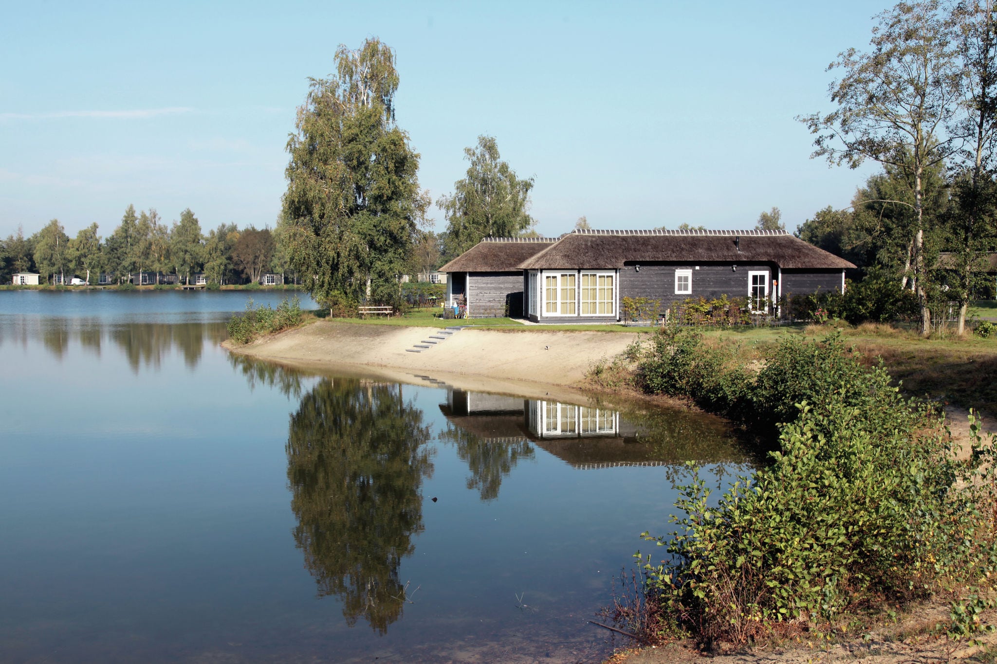 Thatched lodge with a combination microwave, at a holiday park in Twente