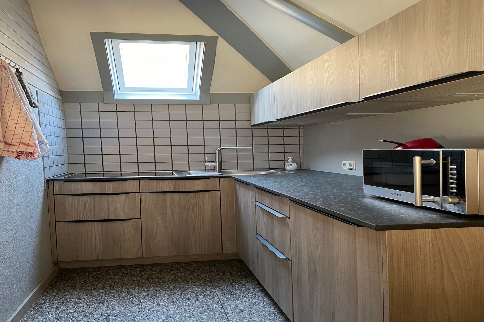 Ground floor: (Entrance, Living/diningroom(TV, dining table, stove, seating area))\n\nmezzanine: (open kitchen(cooker(induction), coffee machine(filter, pads), oven, microwave, dishwasher, fridge-freezer), bathroom(shower, washbasin, toilet), toilet)\n\nAttic: (bedroom(double bed or 2 single beds, washbasin), bedroom(single bed, single bed, washbasin))\n\ngrill, balcony, heating(central), terrace(20 m2), garden(private, 1000 m2), garden furniture, parking