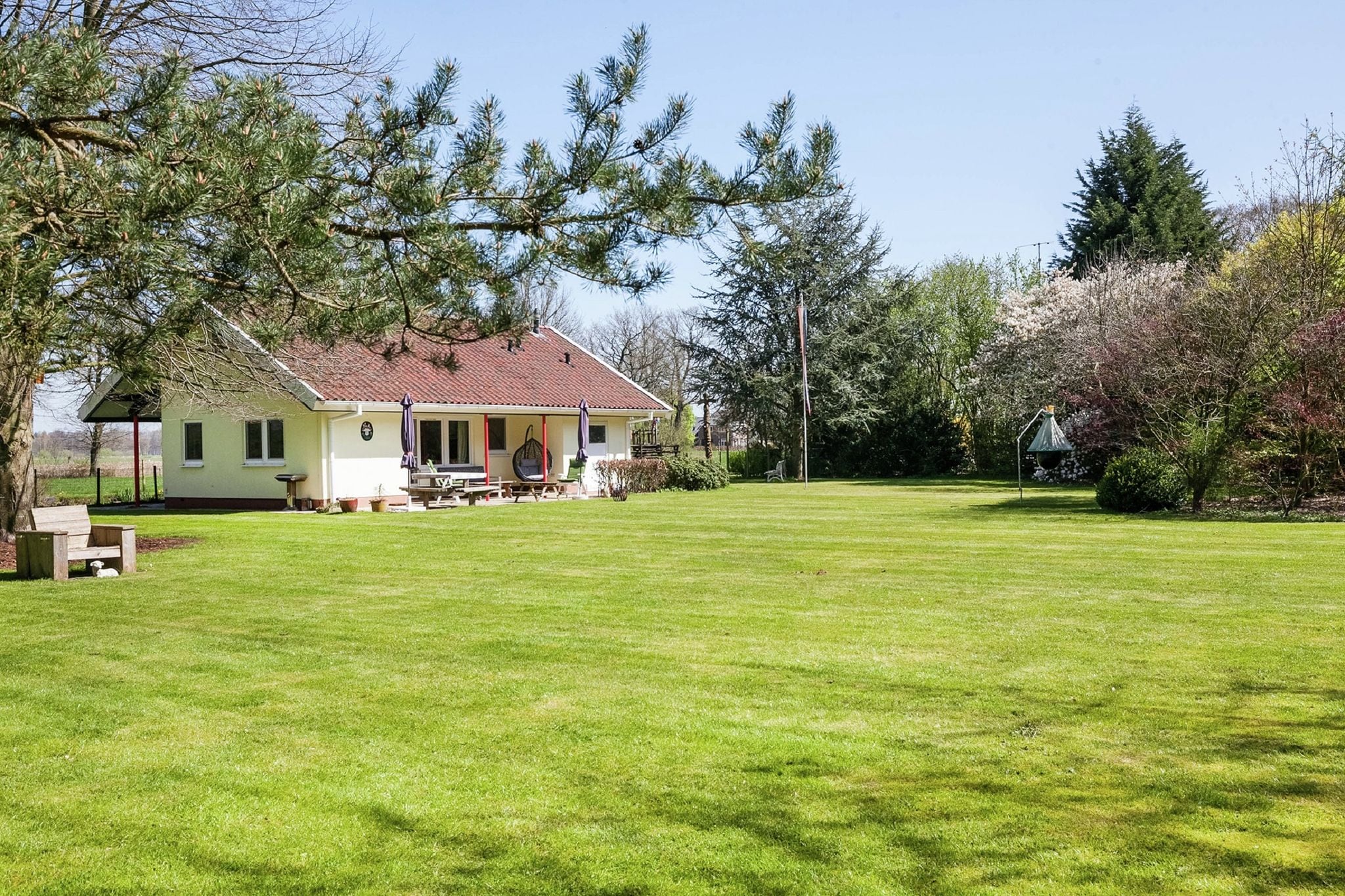 Maison indépendante avec un grand jardin clôturé, des équipements de jeux et une terrasse couverte