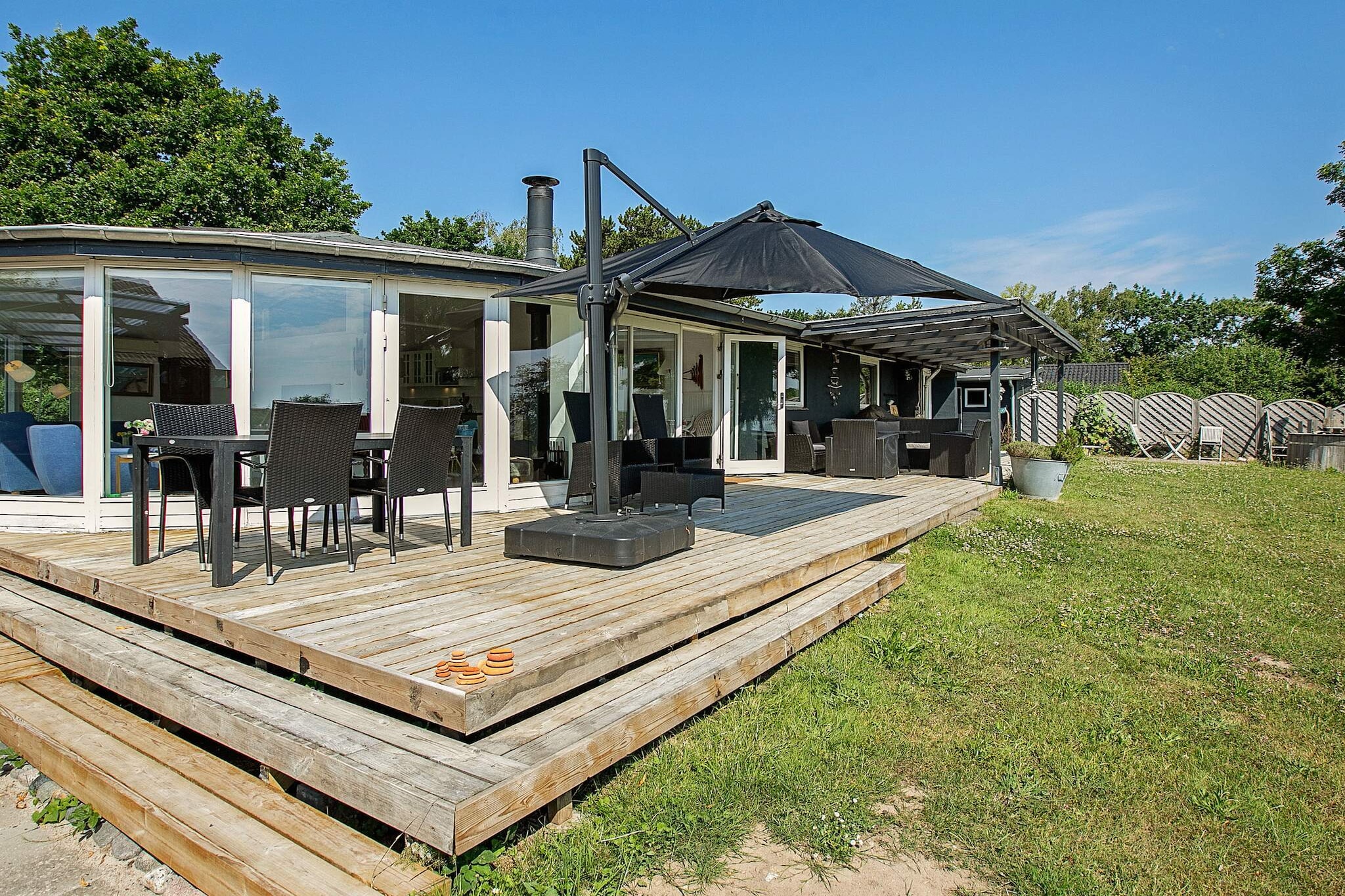 This holiday cottage with whirlpool and wilderness bath, is located with sweeping views of the water on a natural/beach plot in the small cottage area in Tranekær. The view of the water can be enjoyed either from one of the terraces or you can sit on the shore and enjoy the sounds of the sea with your feet in the water. You can fish right from the beach. The house was built in the '60s, continually refreshed with e.g. renovated kitchen and bathroom with 4-person whirlpool from which you can also enjoy the water views. There is a steam cabin for 2 people. 4 bedrooms. The mezzanine is best suited for children as it is very small. Outdoor shower with hot water as well as a fish cleaning table and a campfire. For children there are swings. The house is heated with a heat pump, reducing the consumption of electric heating.A refundable deposit might be charged closer to your check-in date. The security deposit ensures a smooth stay and covers any additional services or consumption charges.This deposit covers utilities consumed during your stay and any additional services that may be taken.The final amount will be adjusted based on actual meter readings, actual usage of extra services, and any remaining balance will be refunded within 21 days after checkout.This deposit simply acts as a prepayment for charges that  you would anyways pay for, ensuring a seamless stay and check-out experience.