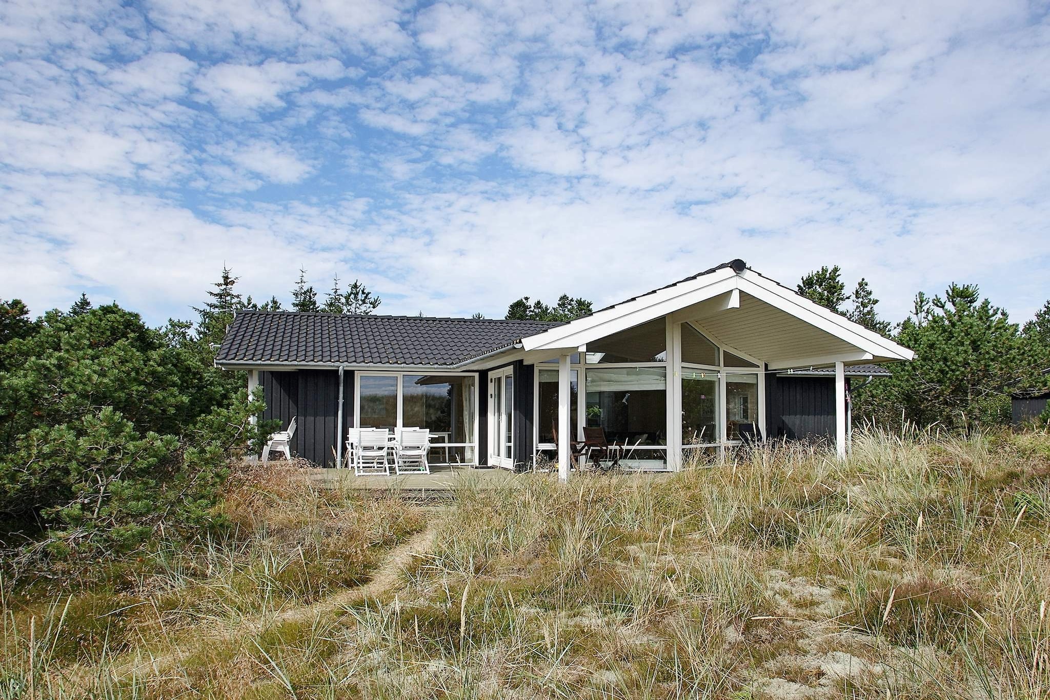 A holiday cottage with a whirlpool, located on the 1st row on a sand dune plot with its own pathway leading directly down to the beach. The beach is approx. 50 metres away. The house is located on a 2700 m² secluded natural plot. Large kitchen and living room with a view of the surrounding scenery. The mezzanine with its two extra beds is suitable for children. The  windows of the house give a great inflow of light. This is a bright and well-arranged holiday cottage. There is a terrace that surrounds the house where you can soak up the sun.A refundable deposit might be charged closer to your check-in date. The security deposit ensures a smooth stay and covers any additional services or consumption charges.This deposit covers utilities consumed during your stay and any additional services that may be taken.The final amount will be adjusted based on actual meter readings, actual usage of extra services, and any remaining balance will be refunded within 21 days after checkout.This deposit simply acts as a prepayment for charges that  you would anyways pay for, ensuring a seamless stay and check-out experience.