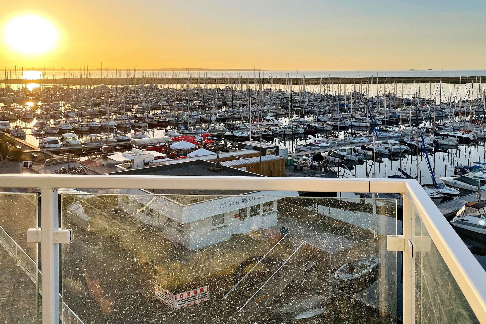 Welcome to your Baltic Sea escape, a modern penthouse apartment right on the harbour front of Marina Wendtorf. The heart of this home is its 17 sqm roof terrace, where you can soak up sweeping sea views from sunrise to sunset. With two sun loungers and a dining set, it’s the perfect spot for lazy mornings, alfresco meals, or simply watching the boats glide through the marina. Inside, the apartment is designed for both comfort and style. The open-plan kitchen and living area flows directly onto the terrace and is equipped with everything you need, including a stove and a WOK hob for those who love to cook. The bedroom features a cosy double bed and flat-screen TV, while the sleek bathroom invites you to unwind with a rain shower, steam bath function, and warm underfloor heating. Evenings can be spent curled up by the bioethanol fireplace, watching a film on the Blu-Ray player or streaming music through the Bluetooth soundbar. An elevator makes access easy, and a private parking space is ready for your car. Binoculars are available too, so you can enjoy close-up views of the harbour life right from your terrace. Families will also feel at home here, kids can run and play on the promenade playgrounds or discover the nearby activity centre with climbing, slides, and even black-light mini golf. Admission is free for all DanCenter guests. This penthouse combines modern living, a prime location, and a touch of seaside magic—an unforgettable setting for your next holiday.A refundable deposit might be charged closer to your check-in date. The security deposit ensures a smooth stay and covers any additional services or consumption charges.This deposit covers utilities consumed during your stay and any additional services that may be taken.The final amount will be adjusted based on actual meter readings, actual usage of extra services, and any remaining balance will be refunded within 21 days after checkout.This deposit simply acts as a prepayment for charges that you would anyways pay for, ensuring a seamless stay and check-out experience.