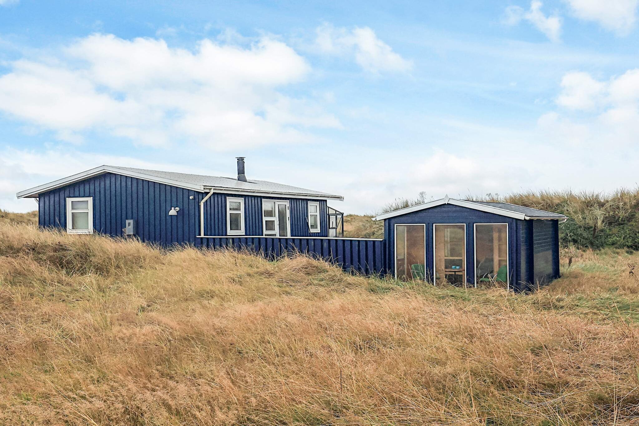 Holiday home with a unique location right down to the dunes and the sea by the child-friendly beach north of Ålbæk. You can enjoy a bath in the hot tub and a trip to the sauna after a walk in the area. The cottage is well furnished with a conservatory, where you can spend many hours and enjoy the fantastic nature. The house has a small well equipped kitchen from which there is a view of the dunes. There is a wood burning stove in the living room, which you can warm up on the cooler days. Combined washer and dryer. There are both east, south and west facing terraces, from where you can enjoy the sun's rays all day and listen to the sound of the sea.
A refundable deposit might be charged closer to your check-in date. This deposit covers utilities consumed during your stay and any additional services that may be taken. The final amount will be adjusted based on actual meter readings, actual usage of extra services, and any remaining balance will be refunded within 21 days after checkout.
