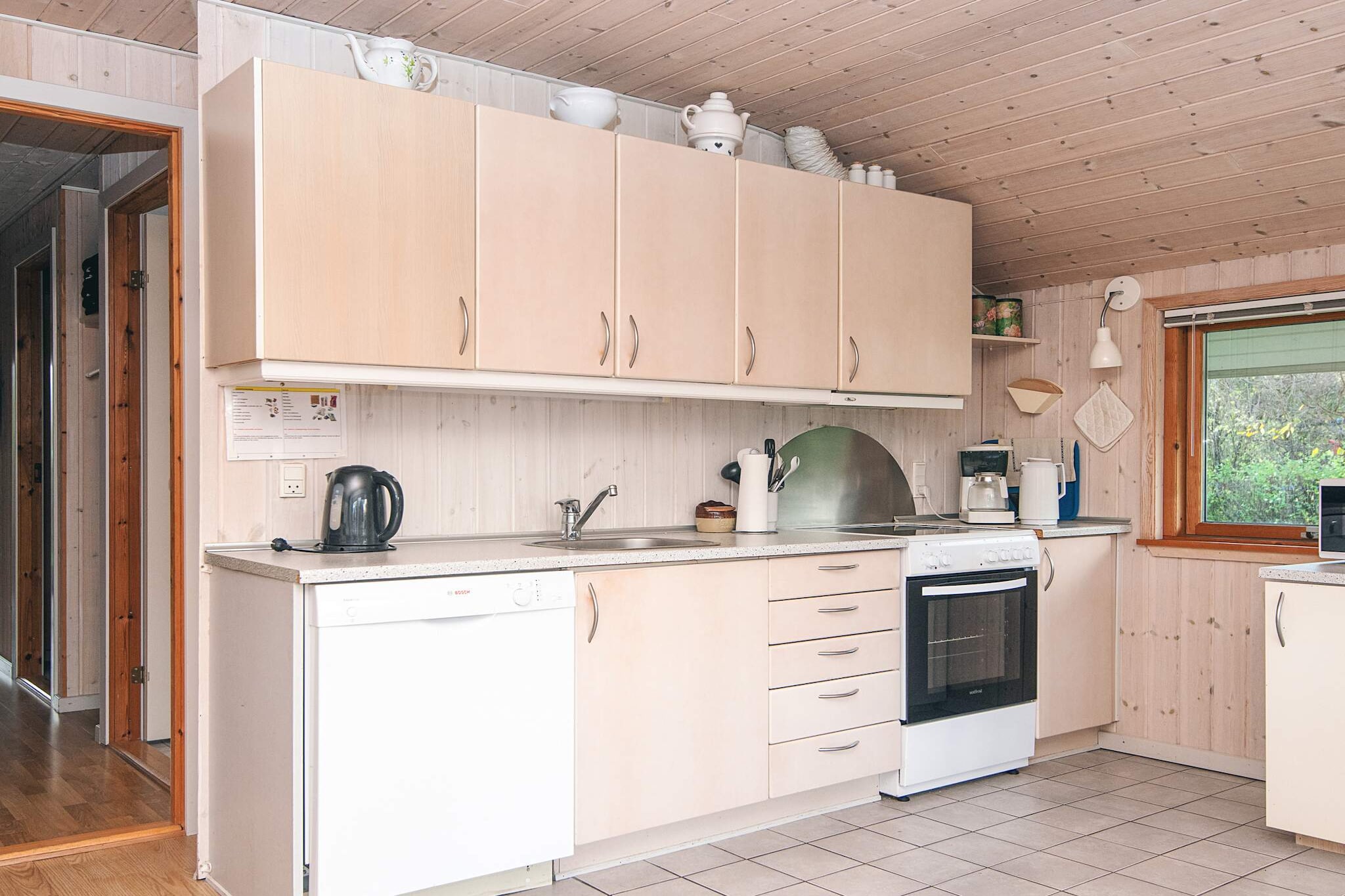 open kitchen(cooker(electric), hood, coffee machine, microwave, dishwasher, fridge-freezer, washing machine), Living/bed room(TV(satellite, german television channels, danish TV channels (DR1 and TV2)), radio, CD player), bedroom(double bed, high chair), bedroom(double bed), bedroom(double bed), bedroom(single bed), bathroom(floor heating)(bathtub or shower, washbasin, toilet), heating(electric), terrace(roofed), garden furniture, BBQ, play equipment