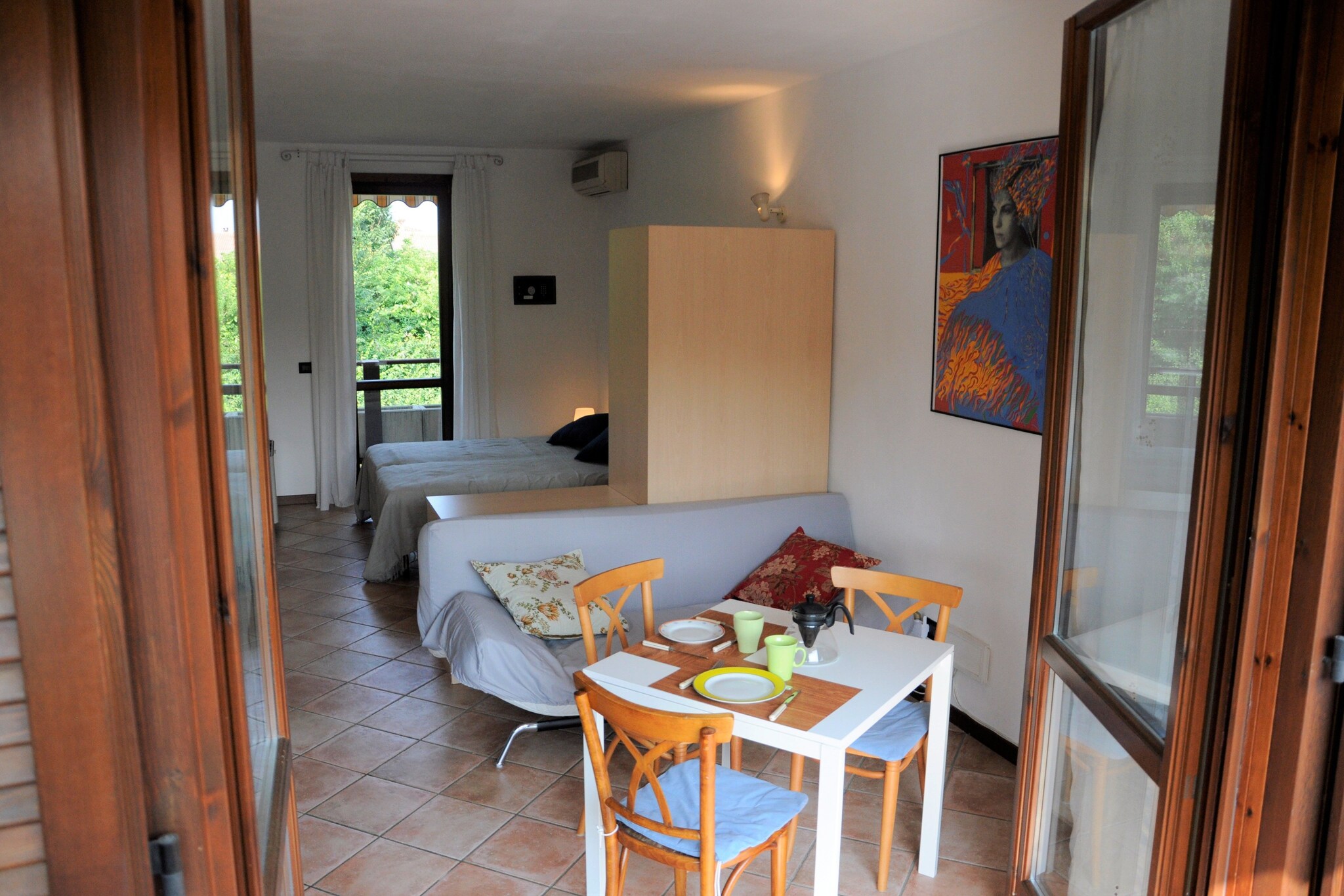 This living/bedroom holiday home for a small family or a couple with a toddler rests in Lazise, close to Lake Garda. To take a refreshing dip on a hot summer day, you have a shared swimming pool a few steps away. The home can accommodate a total of 3 guests.
The holiday home enjoys a central position, at only 1 km from the lake and from the ancient town walls of Lazise. Restaurants to enjoy Italian delights and supermarkets to fetch groceries are within a walking distance, at 0.3 km and 0.4 km, respectively. Gardaland and Caneva Aquapark are great to enjoy a water-filled day with kids. The beautiful cities of Venice and Milan are nearby for day-trips.
The holiday home has central heating as well as air-conditioning. Before retiring to bed, you comfortably watch your favorite movies on TV. The new recipes you try in the kitchen can be enjoyed on the balcony. After returning from walks and excursions, you can relax in the garden. A garage is available.