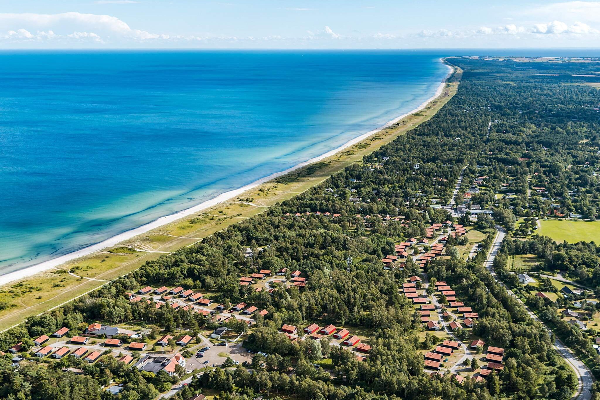 Marielyst Holiday Center Located directly next to 20 km of sandy beach and the Baltic Sea as far as the eye can see. Here you will find nature, beach, water and wildlife in rich quantities. Watch movies on YouTube. About Marielyst Holiday Center At Marielyst Holiday Center you have 20 km of sandy beach at your feet. At the end of the sand, the Baltic Sea extends far into the blue. Just behind, between aspen and beech, is your holiday home in the scenic area we call & # 8221; The Fragrant Plantation & # 8221 ;. Snuff in & # 8211; and see if you can distinguish the shades from the many different types of wood and then of course the salty sea. If there are small animal keepers in the family, they get busy in the morning. Stick them a piece of bread so they can claim the curious pheasants that roll around all year round in their beautiful feather splendor. Or experience the many & # 8221; Easter & # 8221; hares running around the plantation during an extended spring weekend with the family. The holiday homes in Marielyst Holiday Center are located right by a fantastic sandy beach. The houses, built of wood and located in the middle of a plantation, are designed with respect for the surrounding nature. Your holiday home is not far from the resort town of Marielyst. The houses are designed by Stephan Kappel. All houses are non-smoking. Holiday home in Marielyst You also have the option of renting a holiday home in Marielyst through DanCenter, if you unexpectedly cannot find a holiday home at Marielyst Holiday Center.