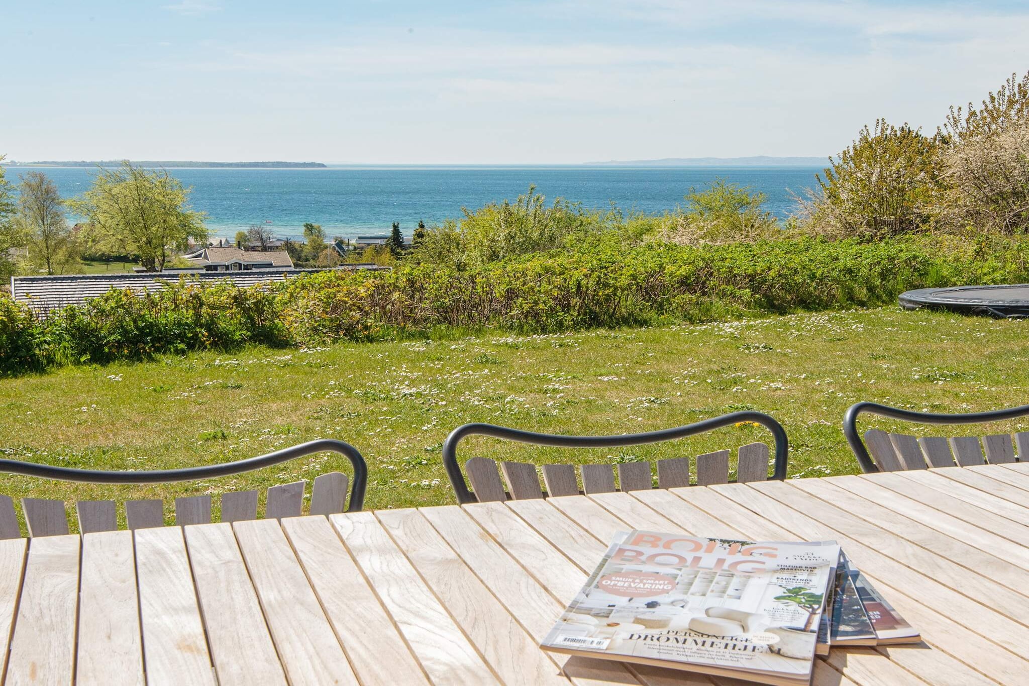 This large swimming pool house is located at one of the plots with the best panoramic view of Ebeltoft cove. 5 bedrooms, all with 2 beds, mean that there is plenty of room for the large family or 2 families sharing. You can also enjoy the view if the ocean from the pool area while the children frolic in the pool. The kitchen, which has e.g. dish washer and microwave oven, is in open connection to the living room so you can have talks while preparing dinner. The wood-burning stove can help create a cosy atmosphere, especially on cold nights. Outside you can enjoy the sun on the terrace and have cosy barbecues. There is a swing for the children. There are several areas on the plot where you can find shelter from the wind. Access from the pool area to the terrace. The house is high-located and has a steep driveway which may be challenging on winter days but at the same time means that the house has a secluded location.A refundable deposit might be charged closer to your check-in date. The security deposit ensures a smooth stay and covers any additional services or consumption charges.This deposit covers utilities consumed during your stay and any additional services that may be taken.The final amount will be adjusted based on actual meter readings, actual usage of extra services, and any remaining balance will be refunded within 21 days after checkout.This deposit simply acts as a prepayment for charges that  you would anyways pay for, ensuring a seamless stay and check-out experience.