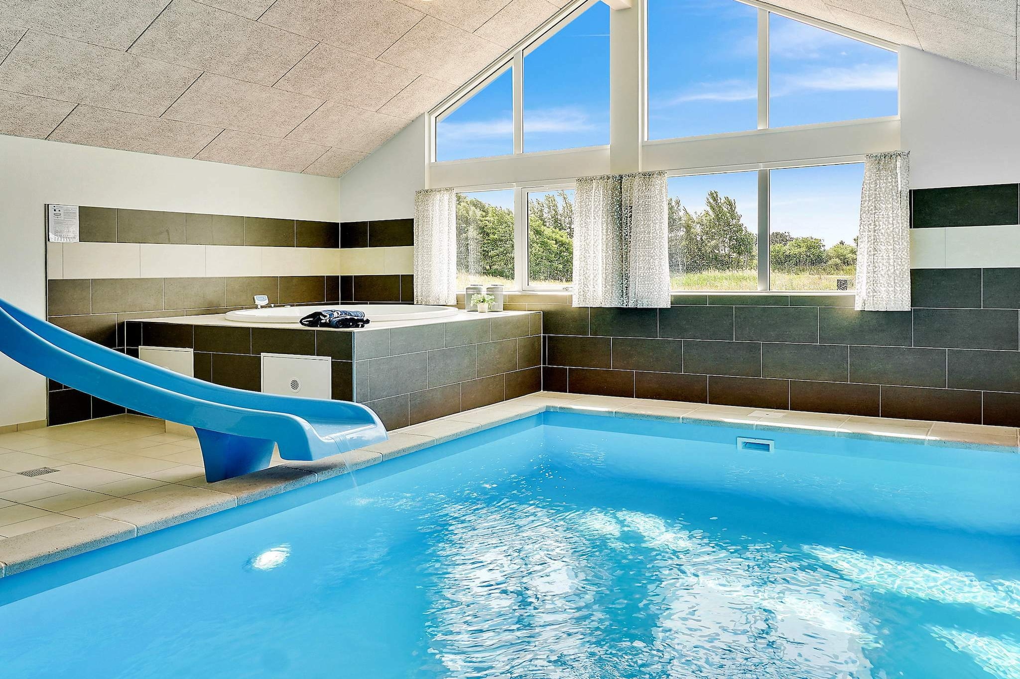 This well-appointed holiday cottage at Vejby Strand has a large pool section with swimming pool with slide, a sauna, shower and whirlpool for 4-6 people. After a good and exiting day you can relax in the whirlpool or get warm in the sauna. On the other side of the centrally located dining/living room you will find the activity room. Here you can challenge eachother in a game of darts or billiards. There is also table tennis and table football. You will even find stereo set, PlayStation4 and a flatscreen TV in the activity room. The house is very spacious and built around 2 separate sleeping sections. Each section has a bathroom and you will find an extra bathroom near the pool area. A total of 3 bathrooms, all with shower cubicle and underfloor heating. One of the bedrooms furthermore has a children's toilet. All 6 bedrooms and the mezzanine have box-mattresses. Underfloor heating throughout the entire house. The living/dining room is tastefully furnished with i.a. stereo set with CD player, TV, DVD player, high chair, sofa section and a wood-burning stove. On the plot you will find swings, a sand pit and a play tower for the children to enjoy. There is also a trampoline (usage at own risk/insurance). There is a large, open terrace as well as a covered terrace - perfect for barbecues. No letting to youth groups.