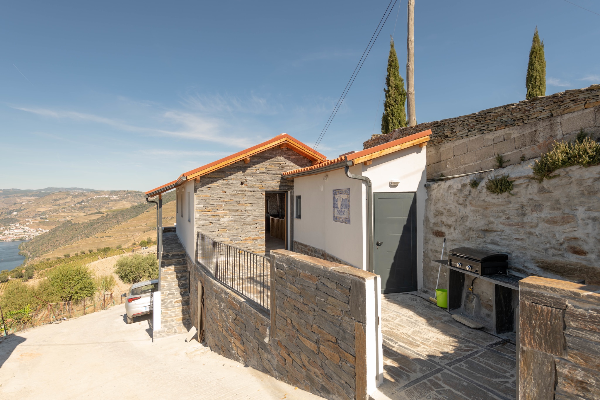 This authentic holiday home in Valença do Douro is surrounded by mountain views. A simple, no-fuss property, this 3-bedroom home can accommodate a family of 6. You can warm up and cool off in the bubble bath and swimming pool, outside, while treating your eyes to stunning views.
The home is located in Valença do Douro, in the heart of the Douro valley, which belongs to the world heritage of UNESCO. Nearby is Quinta do Seixo with the vineyards of Sandeman, which can also be visited.
The home is air-conditioned (and heated) so that you can lounge comfortably. The furnished terrace offers a perfect spot for socialising or dining. You can enjoy a nap on the deckchairs or lounge inside in the living cum dining room, which has a wood stove to add to the cosy atmosphere. An open kitchen makes you self-sufficient for your meals at home.