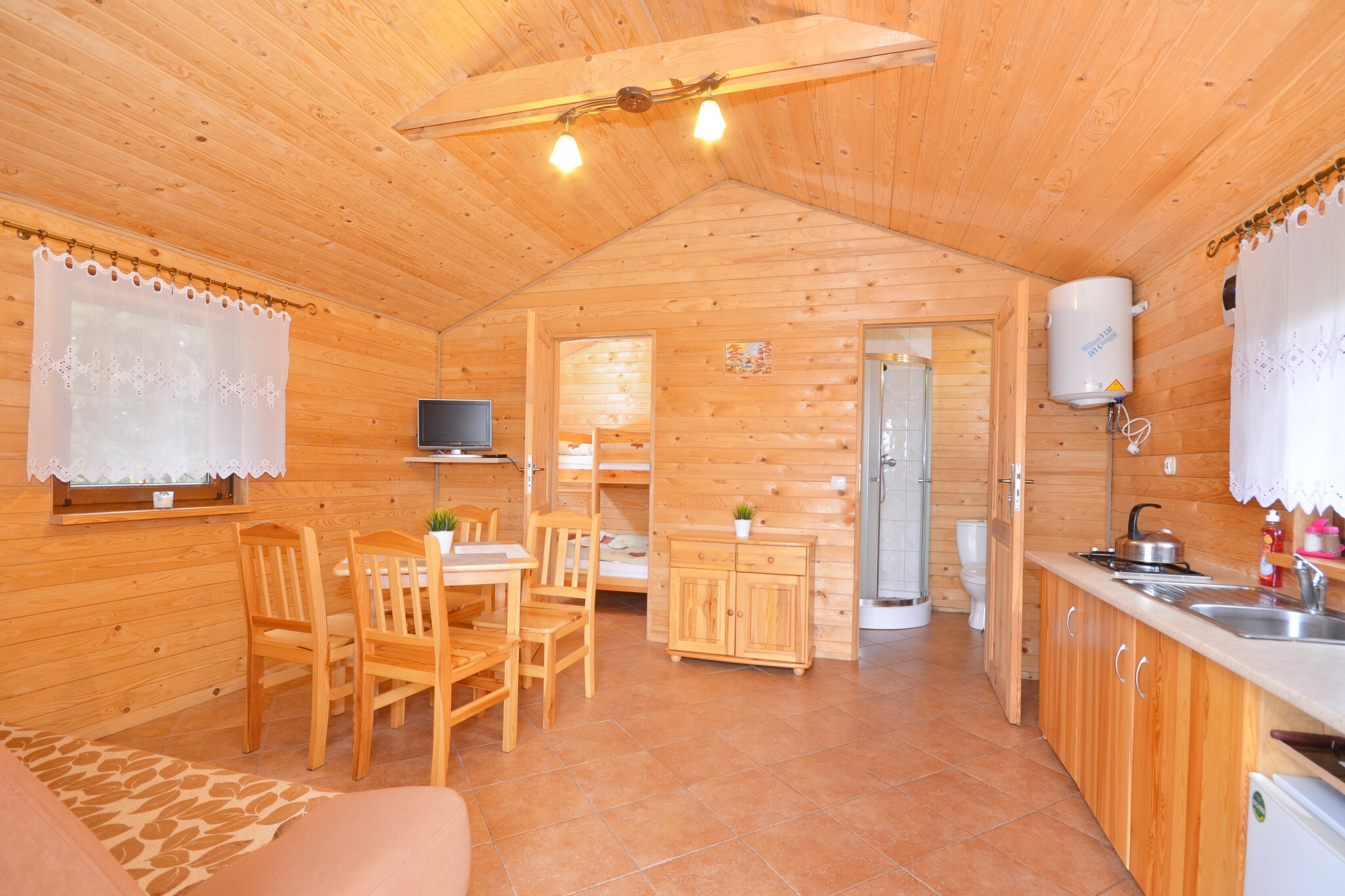 Ground floor: (Kitchenette(electric kettle, cooker, fridge), Living/diningroom(double sofa bed, TV, dining table), bedroom(double loft bed), bathroom(shower, washbasin, toilet))\n\ngrill, garden furniture, parking, trampoline, deckchairs, table football, Volleyball court, Swing set