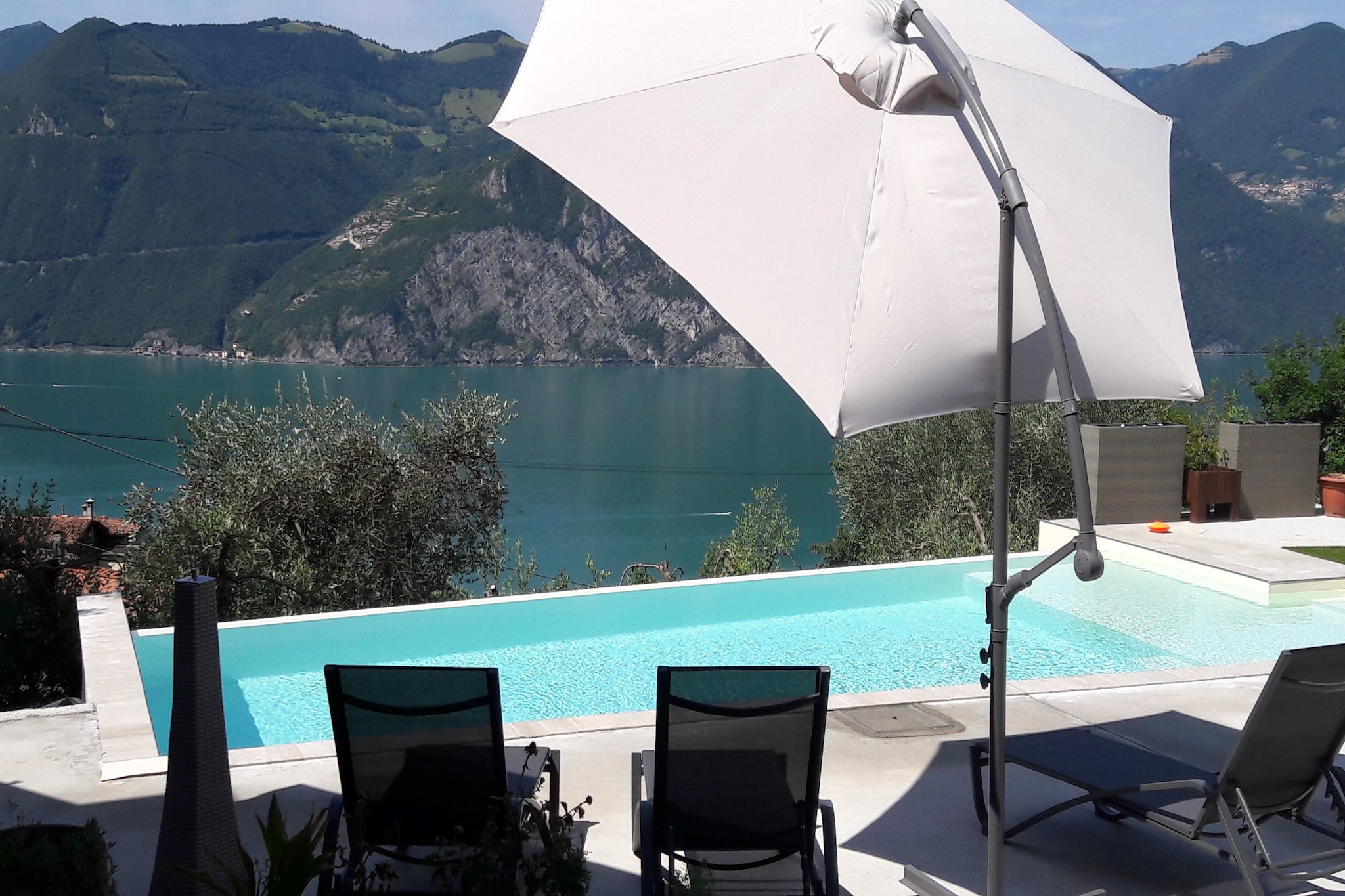 An optional utilities and service fee of EUR 60,00 will be charged before your arrival. Details are given below.<br> Located in the scenic town of Marone near Lake Iseo, this stylish apartment for 4 guests is the perfect base for a relaxing lakeside getaway. Situated on the 2nd floor, the home offers WiFi, modern amenities, and a shared swimming pool (10x4 m, open May-Sep) with sun loungers and a patio area. The open kitchen is well-equipped with a hob, espresso machine, oven, microwave, fridge-freezer, and dishwasher, ideal for preparing meals at home. The bright living/dining area features a comfortable seating and dining space. There are two bedrooms, one with a double bed and one with a bunk bed, making it ideal for couples, friends, or small families. Two bathrooms (one with a bathtub and the other with a shower) offer added comfort, and a washing machine is available in the pantry. Enjoy al fresco dining on the terrace or relax in the shared garden with barbecue facilities. Parking is available on-site. Ristorante Camplani is just 3.7 km away, and the area is known for its natural beauty and lake access. <br><b> Optional Utilities & Service Package </b><br><b> An optional utilities and service package of EUR 60,00 </b> can be selected prior to your arrival. You will receive a separate communication with the payment link should you wish to include it.<br>This package ensures a seamless stay and conveniently covers services such as final cleaning, utility consumption, service support, and protection against minor damages or incidental costs during your stay.<br>Guests who prefer may manage these services independently, provided the property is returned in good order at check-out.