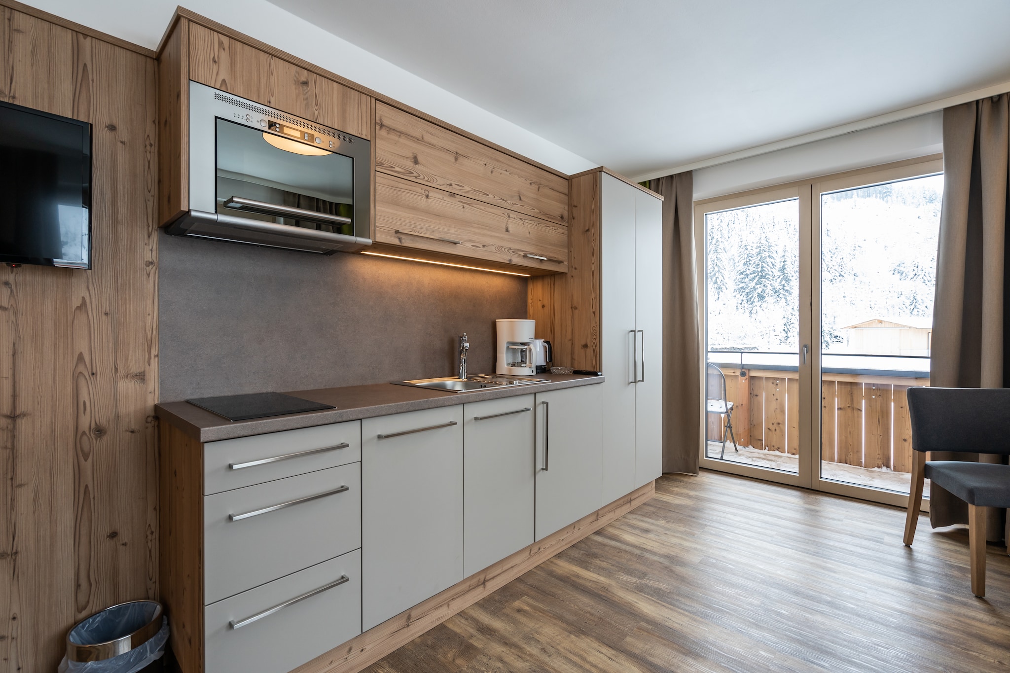 On the 1st floor: (open kitchen(cooker(2 ring stoves), combination microwave, dishwasher, fridge), Living/bed room(double fold-away bed, TV, balcony), bathroom(shower, washbasin, toilet))\n\nrelaxation area(shared with other guests)(shower, 2x sauna, toilet, deckchairs), ski storage(ski boot heaters), toilet, bicycle storage, parking