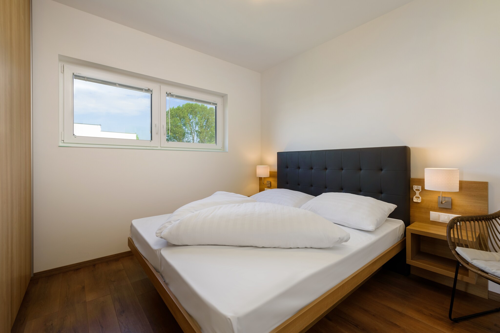 On the 1st floor: (Living room(double sofa bed, TV, balcony), open kitchen(electric kettle, cooker(2 ring stoves), coffee machine(cups), combination microwave, dishwasher, fridge-freezer), bedroom(double bed), bedroom(double bed), bathroom(shower, washbasin, washing machine), toilet)\n\nbalcony, air conditioning, parking, swimming pool(shared with other guests, natural swimming pond)