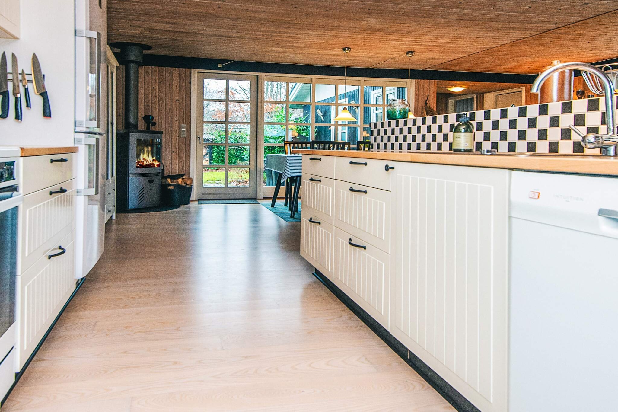 open kitchen(cooker(electric), hood, coffee machine, microwave, dishwasher, fridge-freezer), Living/bed room(TV(german television channels, danish TV channels (DR1 and TV2)), radio), bedroom(double bed), bedroom(double bed), bedroom(double bed), bedroom(2x bunk bed), bathroom(floor heating)(bathtub or shower, washbasin, toilet, washing machine), bathroom(floor heating)(bathtub or shower, washbasin, toilet), shower(outside), heating(electric), terrace, BBQ, play equipment, air to air heatpump